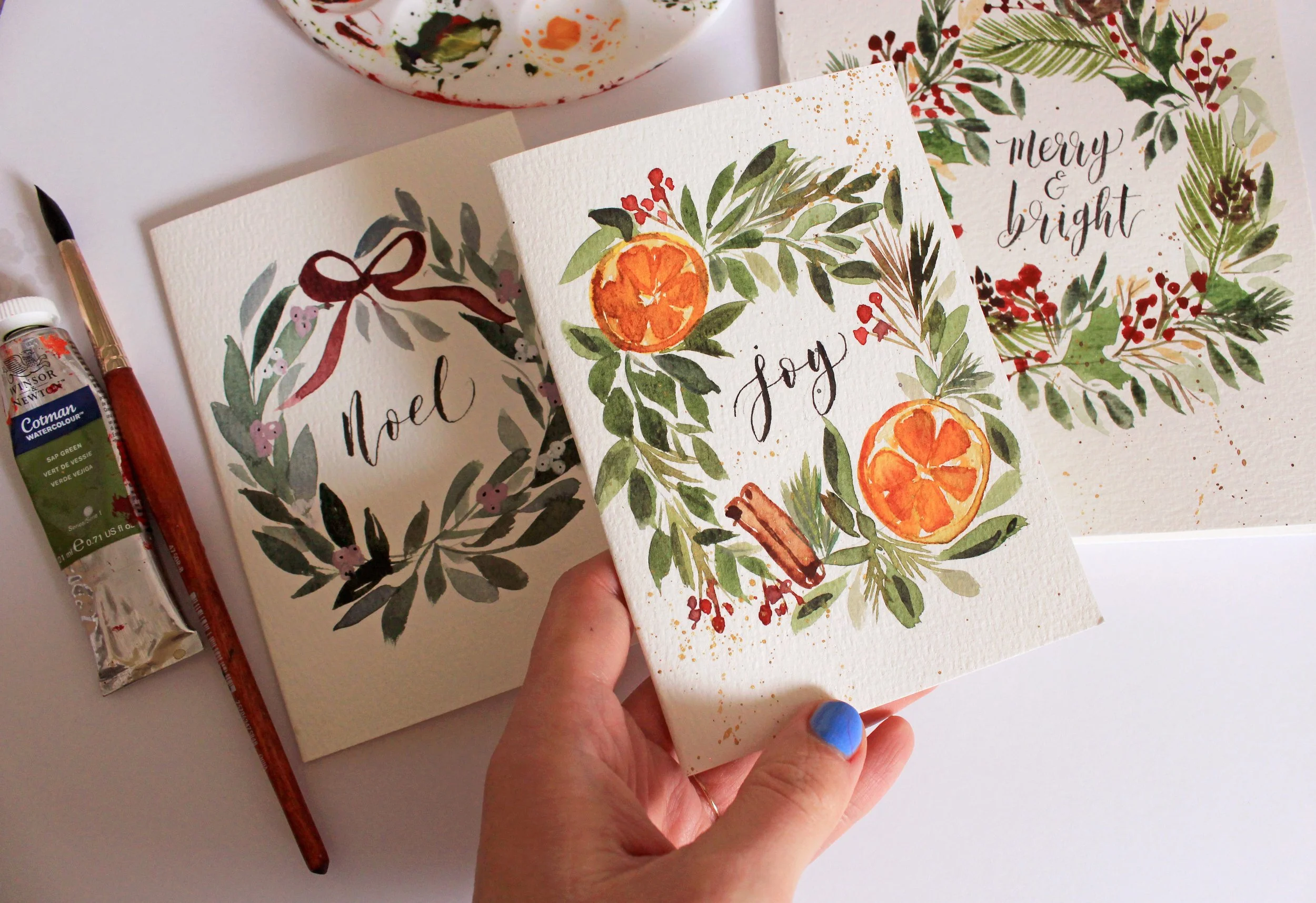 Hand-painted Christmas cards featuring watercolour and brush calligraphy