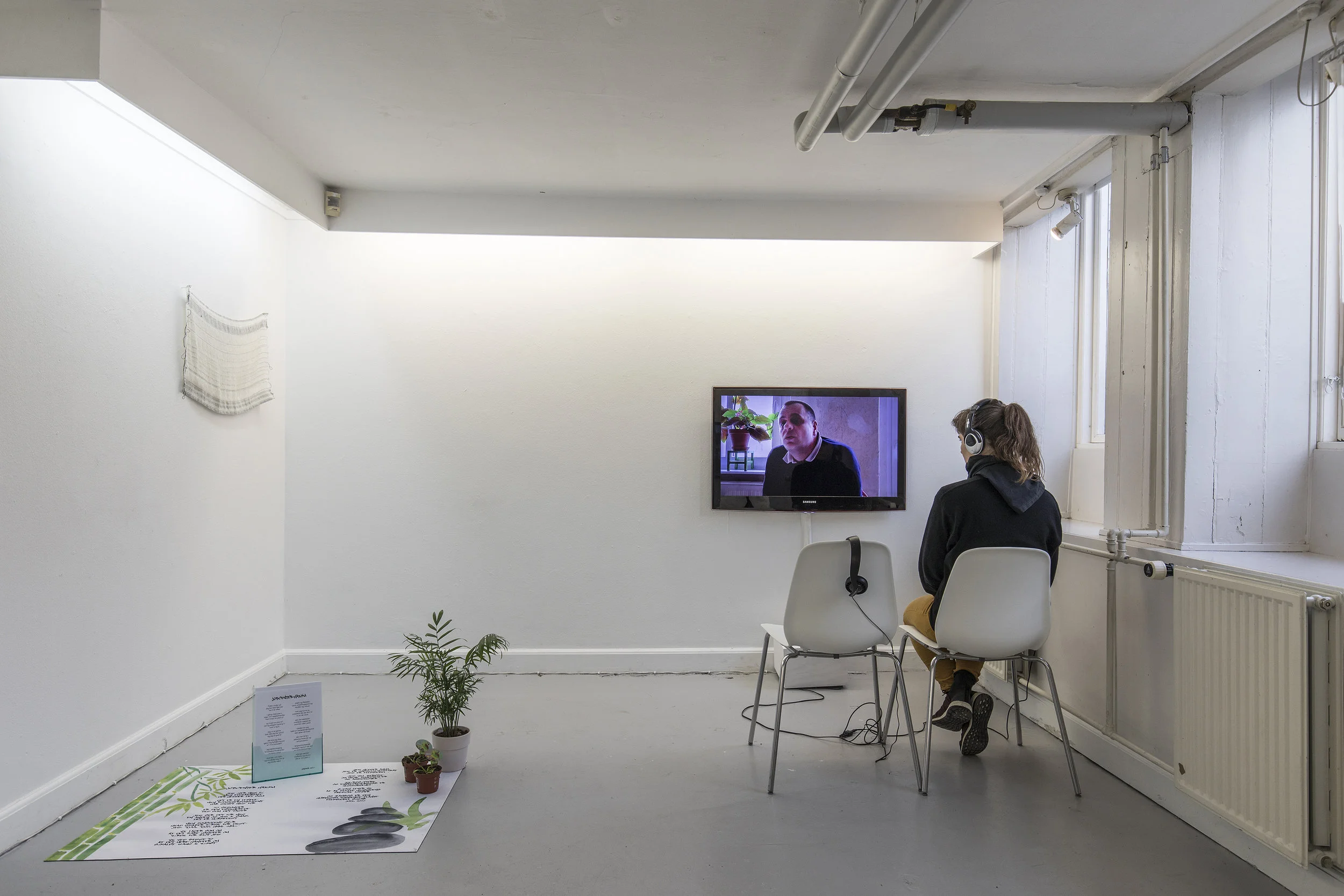 On wall: Udkast til nye strategier/Draft for new strategies by Mette Clausen and Reach, Grasp, Move, Position, Apply Force (video) by Kajsa Dahlberg On floor: Jobcenter-haiku (mixed media) by Anna Ørberg.