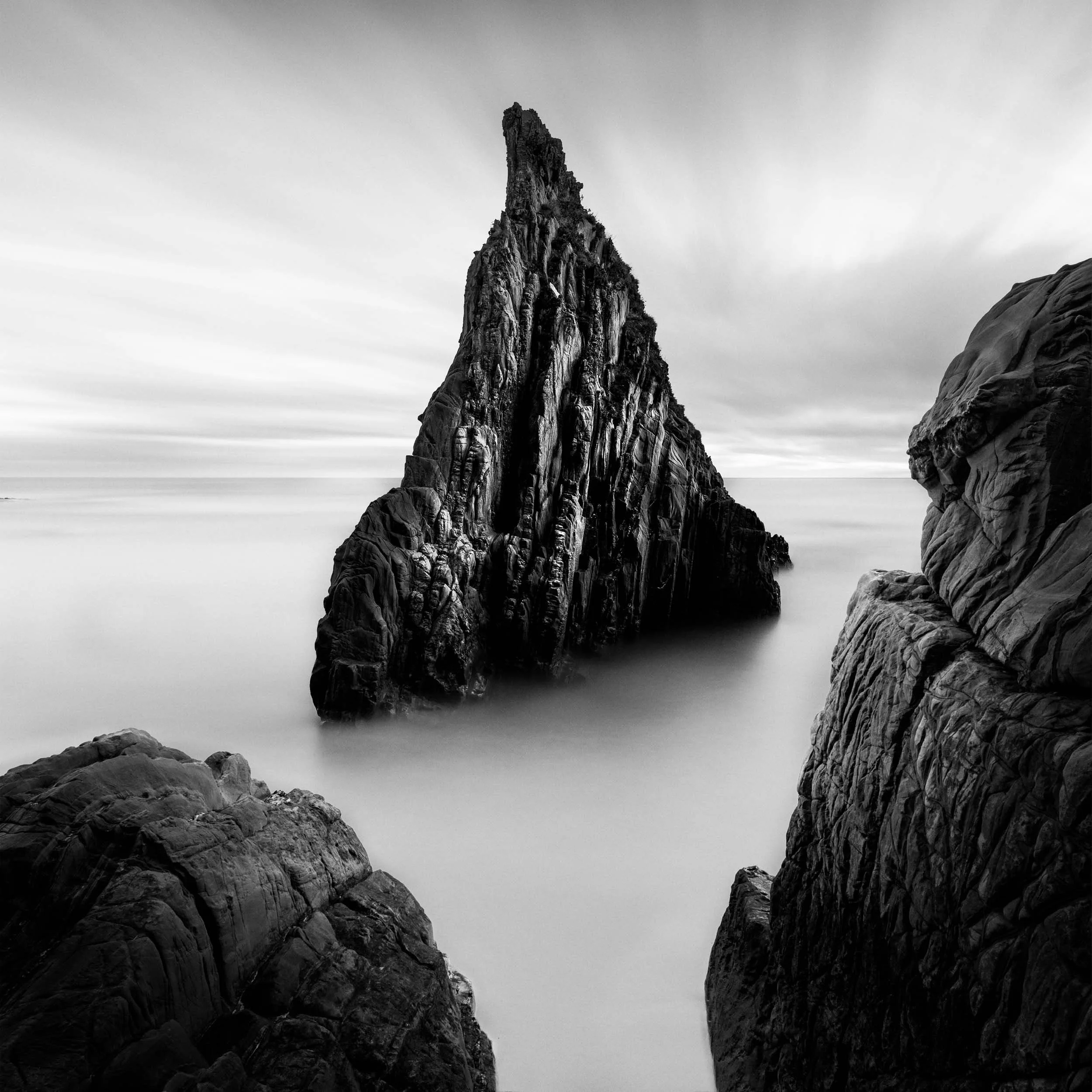 Long exposure of the triangular rock formation in black and white at the playa de mexota in the region of Asturias in northern Spain. 