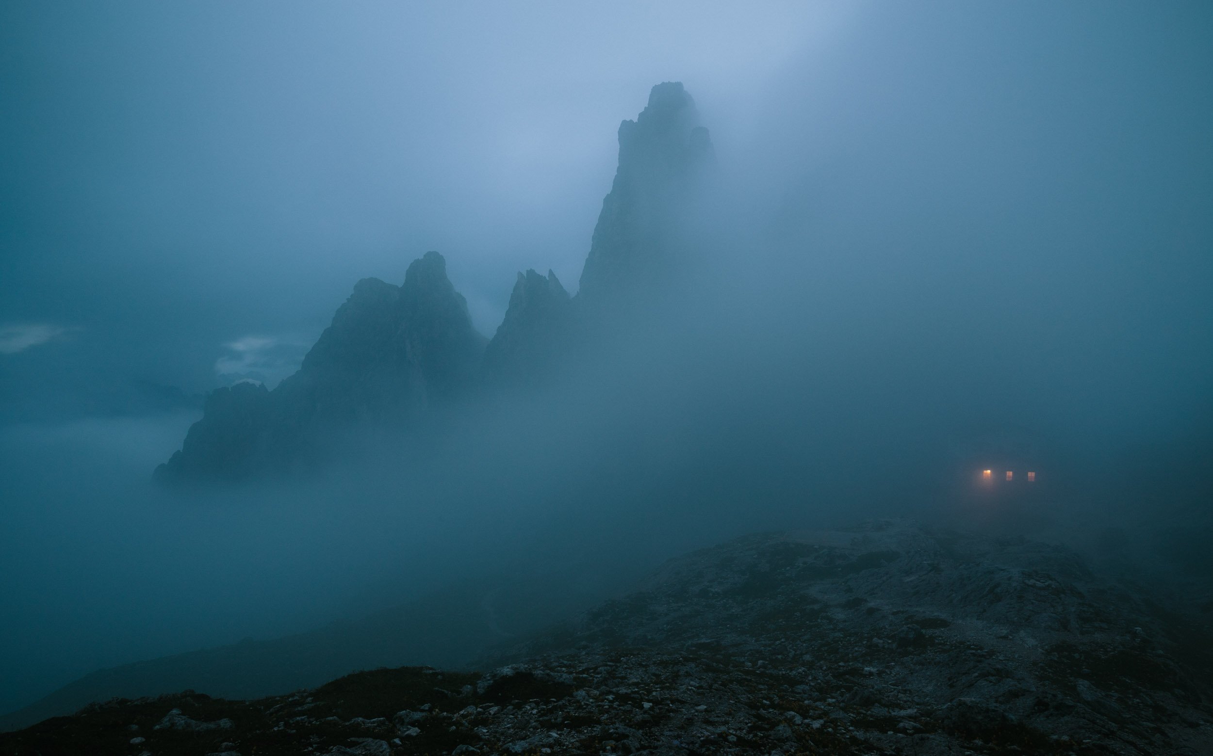 Mountain hut Rifugio Fonda Savio in the Cadini group of the Dolomites covered in clouds. 
