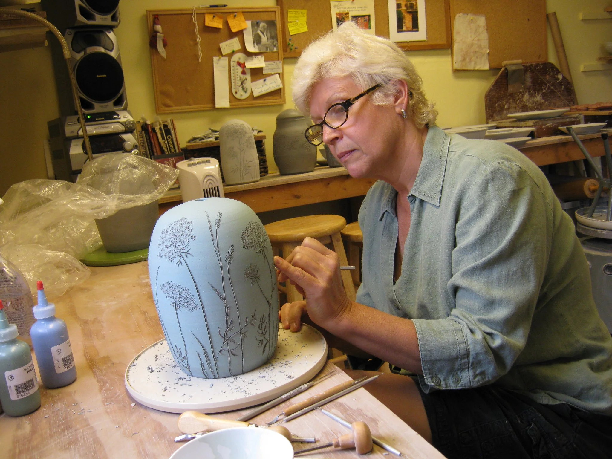 Portrait of Nancy Newlove McElroy painting a pottery piece.