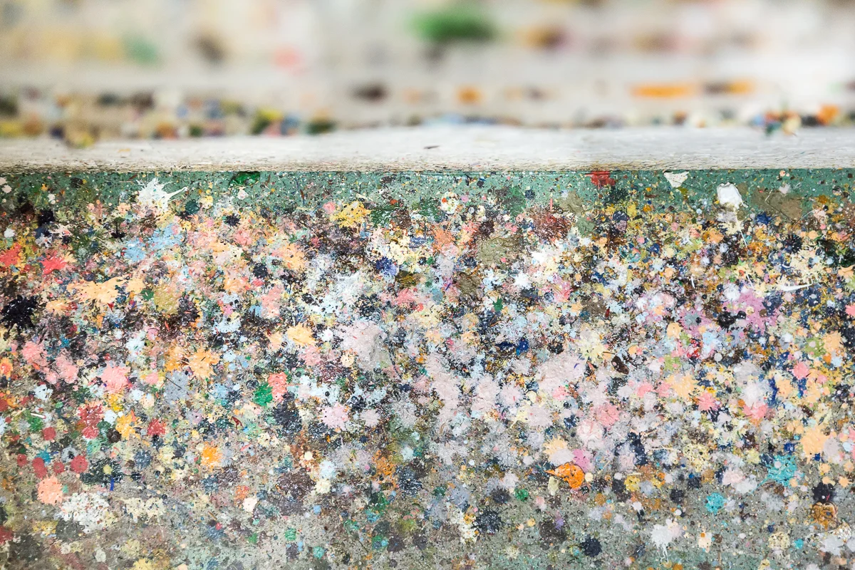 The colorful paint drippings under the spot where Liz paints.