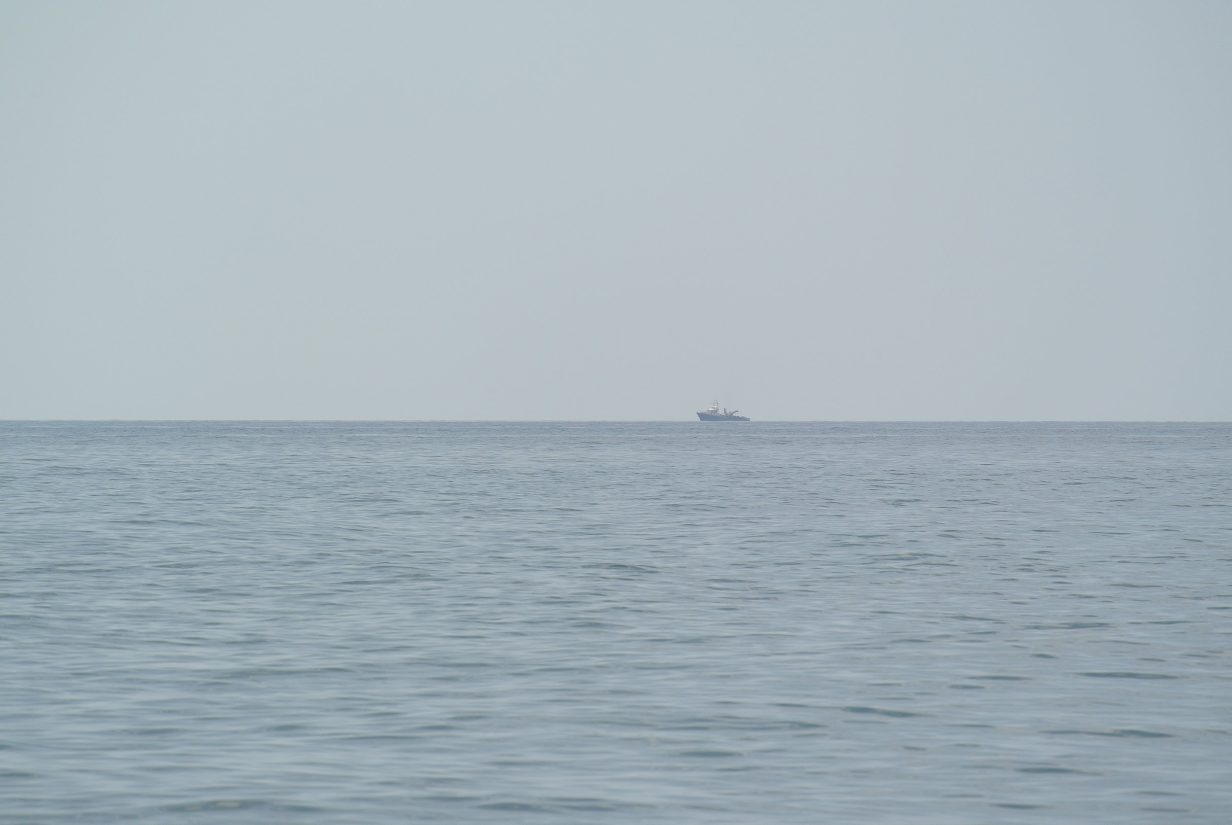   Ships on the horizon resembling rescue vessels. Longobardi, Italia; May 2018. ©Pamela Kerpius  