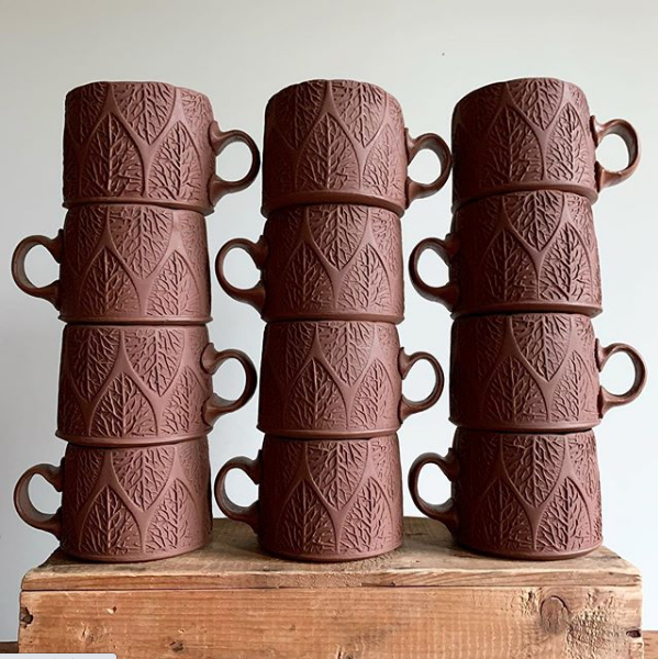 Sarah Pike - stacks of greenware mugs.png