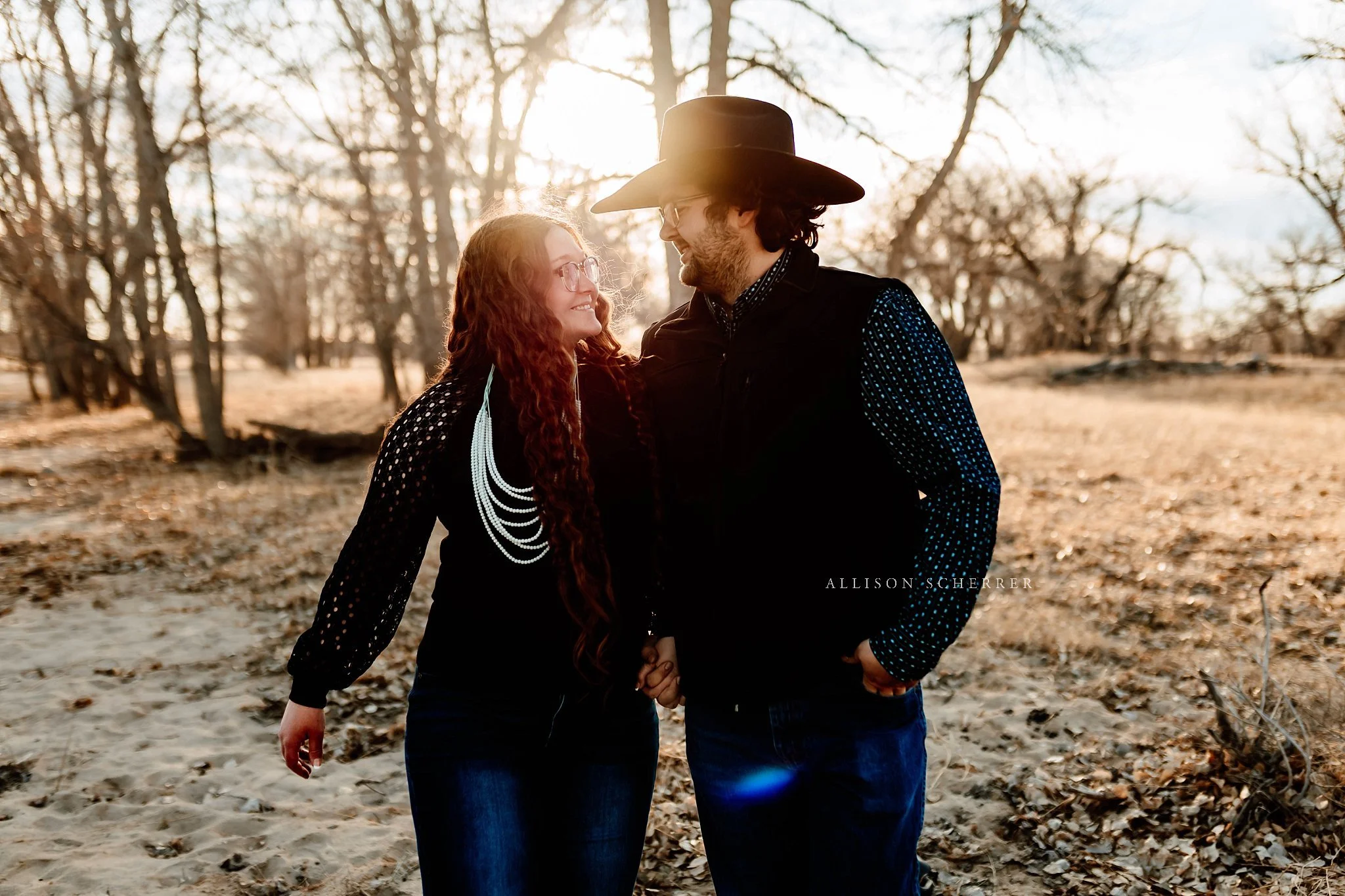 Couple walking during golden hour engagement photos in rural Colorado