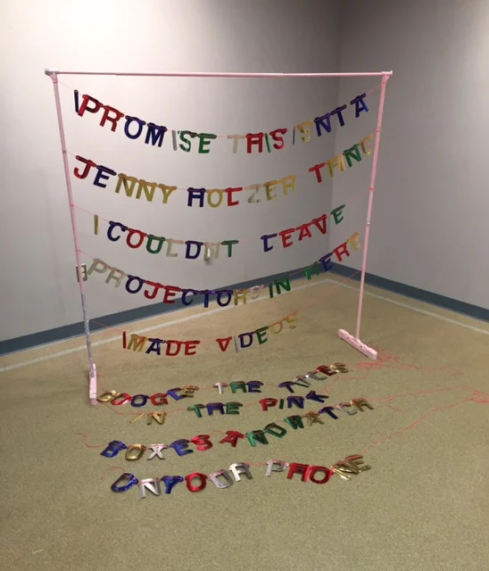 I PROMISE THIS ISN'T A JENNY HOLZER THING I COULDN'T LEAVE PROJECTORS IN HERE I MADE VIDEOS GOOD THE TITLES IN THE PINK BOXES AND WATCH ON YOUR PHONE