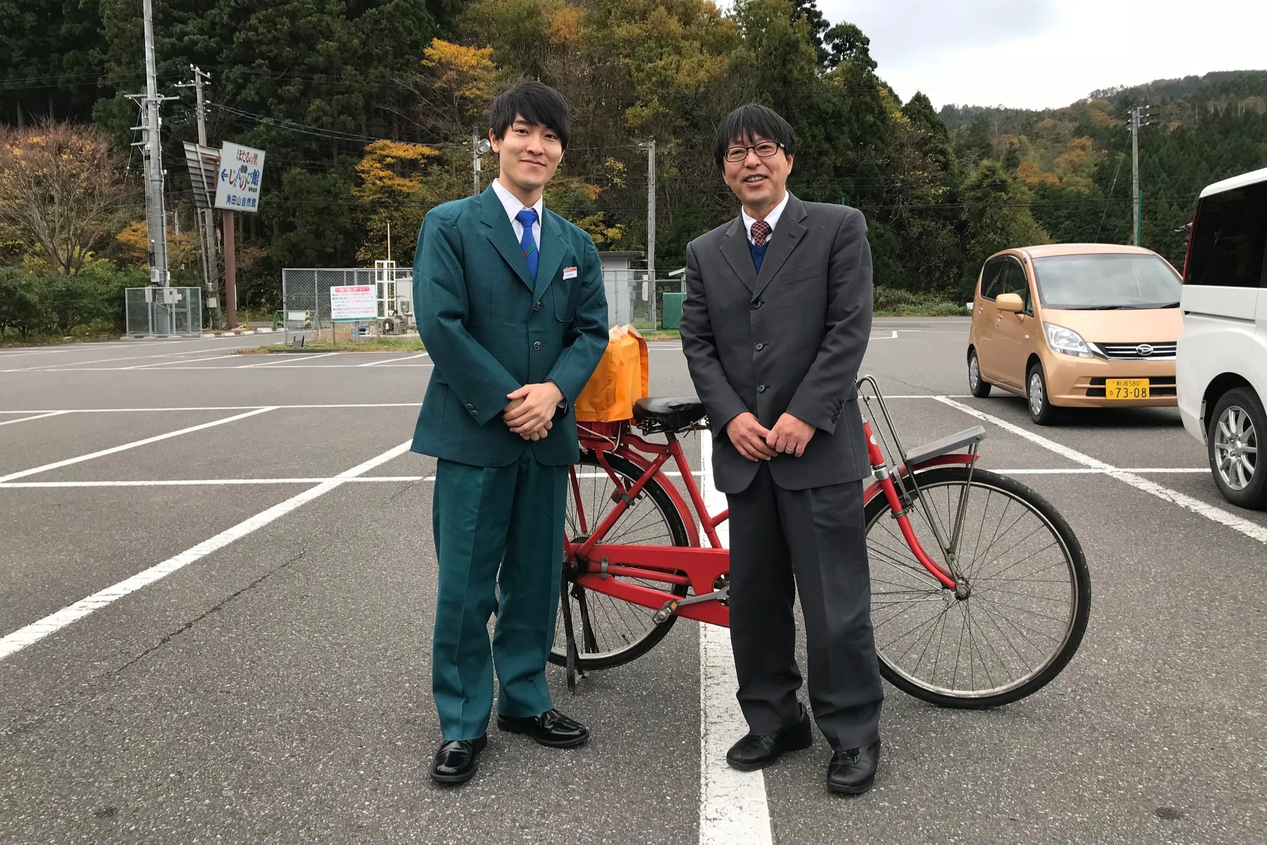 秋編から「ドジな郵便屋さん」の役で登場した岡崎さん。本物の郵便局員さんからアドバイスを受ける。