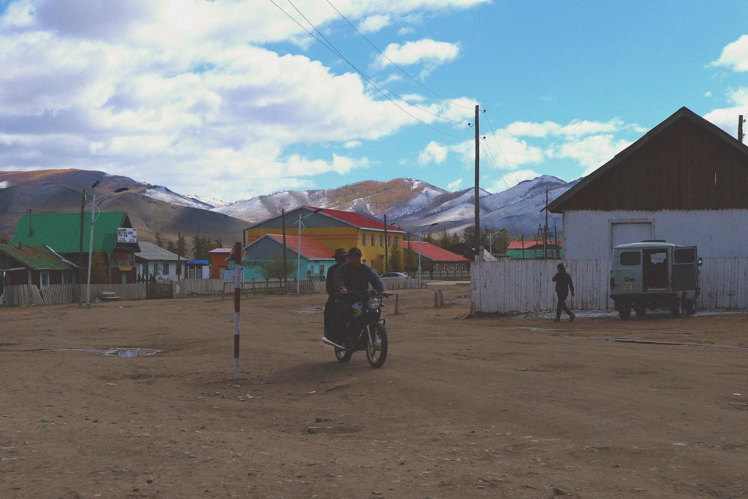 motorbike riding on dirt track in a town in mongolia