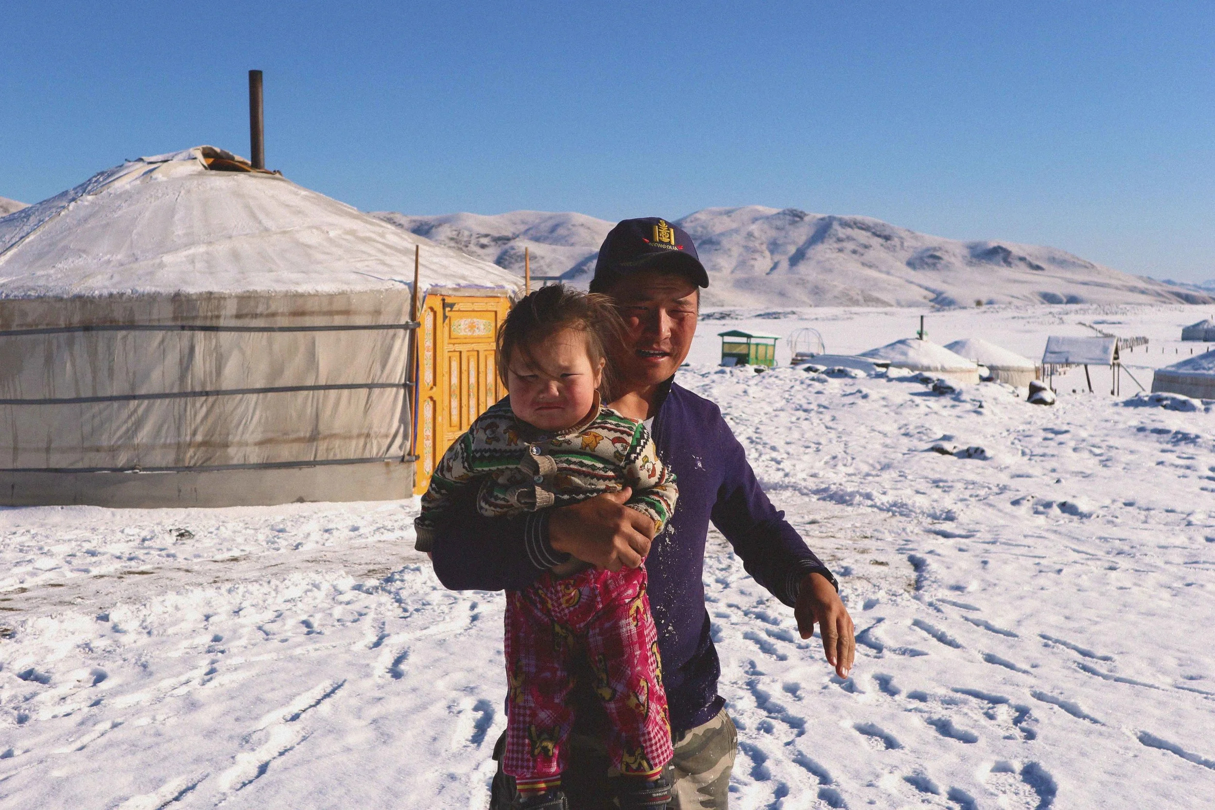 mongolian nomadic nomad man with his son in the snow cold winter in mongolia everyday life