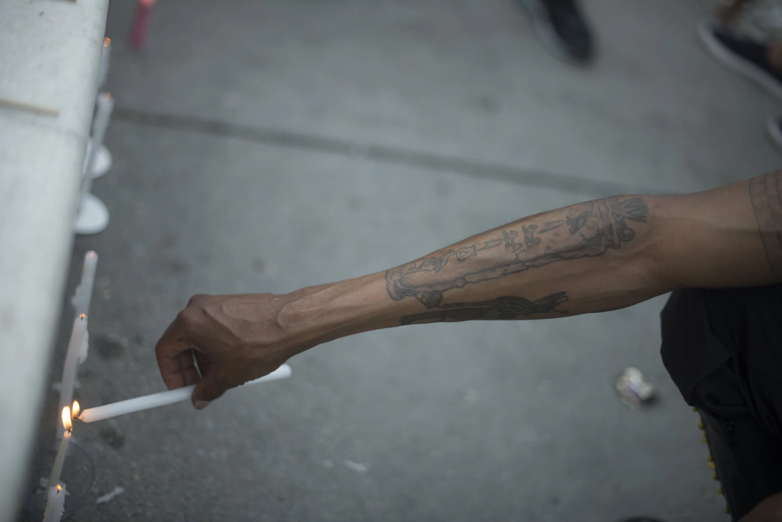  A man carefully lights a candle resting against the fountain of Dupont Circle in Washington, D.C. on June 12, 2017. Hundreds gathered to mourn and remember the Pulse nightclub shooting a year later. 