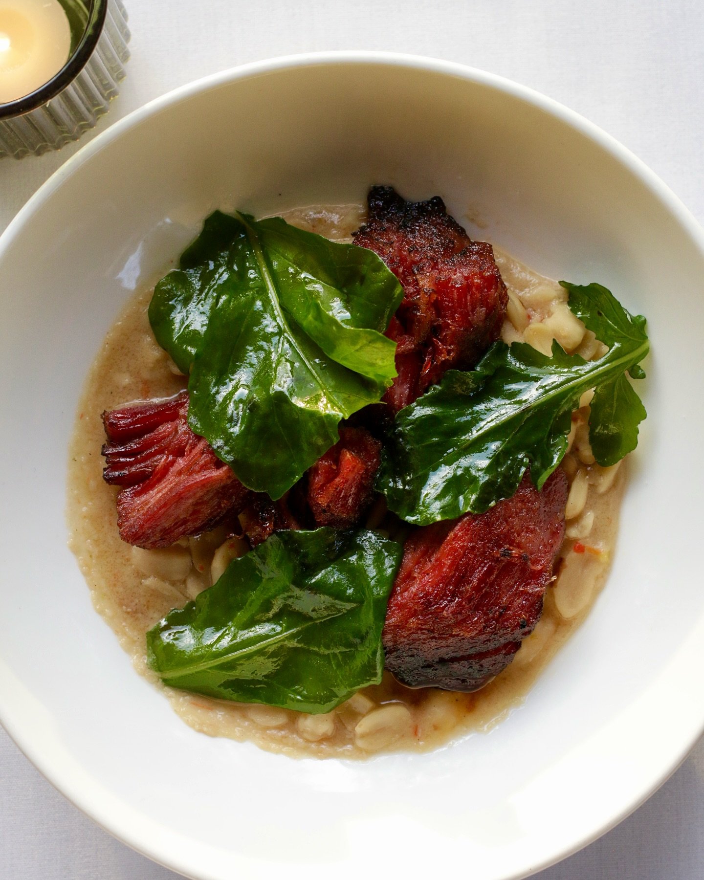 Sunday supper at 5&amp;10 featuring the smoked pork shoulder ham &mdash; pepper jelly-lacquered, with braised peanuts and mustard greens.