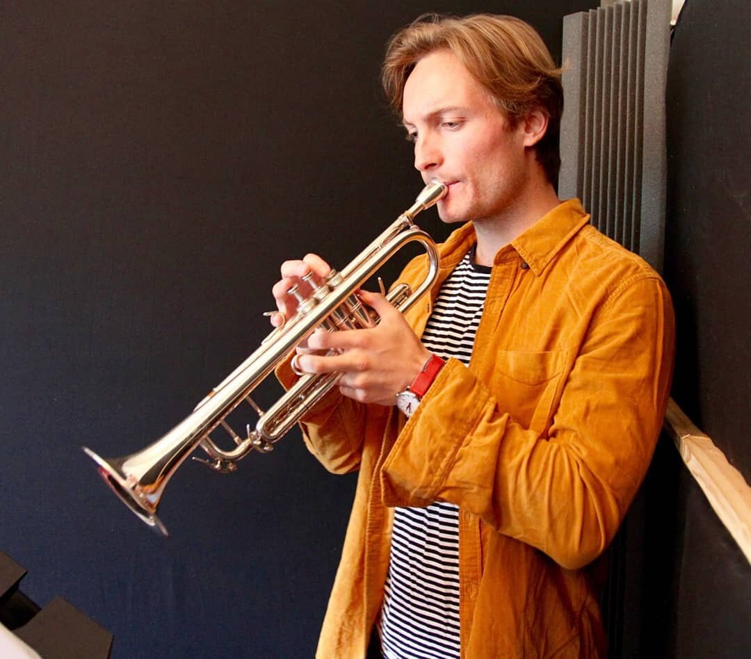 (Read the post below in your best David Attenborough voice)

In the first photo ladies and gentlemen, we see a trumpet player in the studio. He is under the illusion he is cool with his floofy hair. Initially, he believes all the practice he did in l