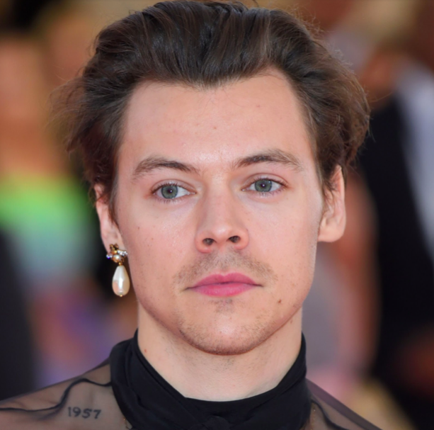 Harry Styles wearing dangly pearl earring.