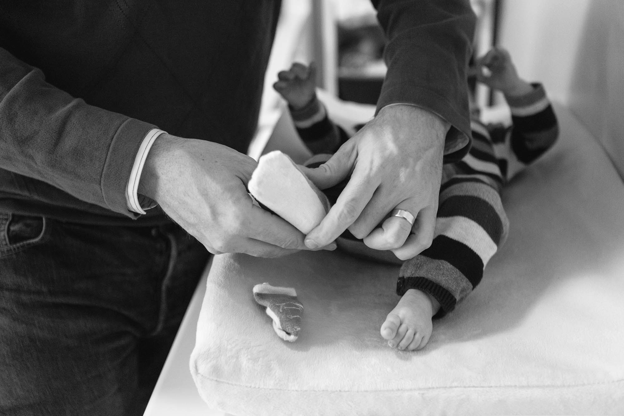 Dad changing babys tiny socks.jpg