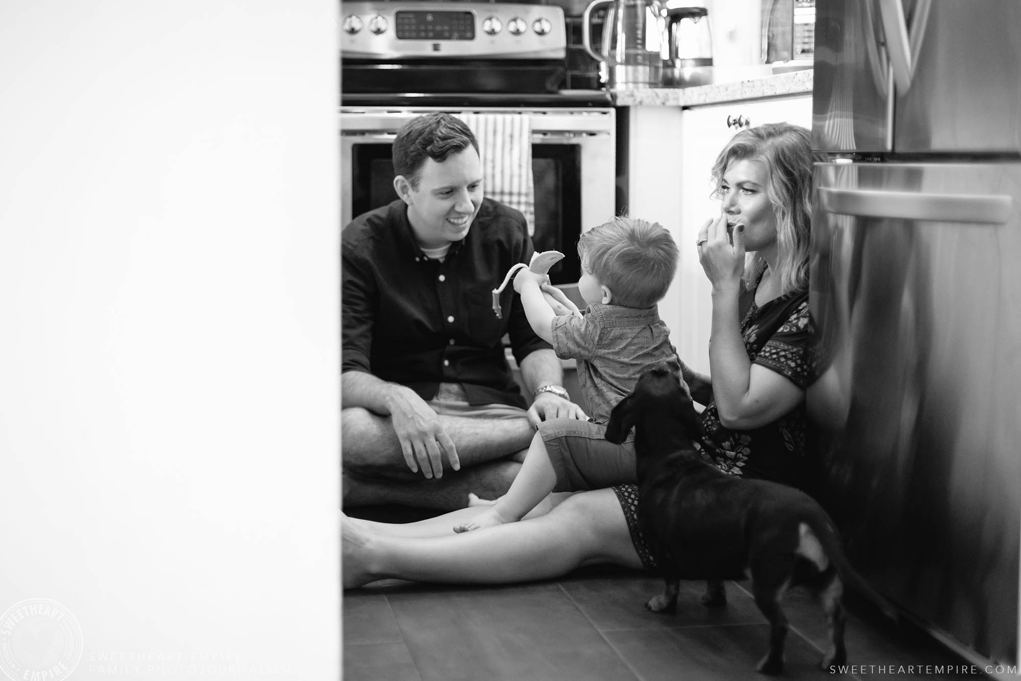 09_Toddler shares banana with his parents while sitting on kitchen floor.jpg