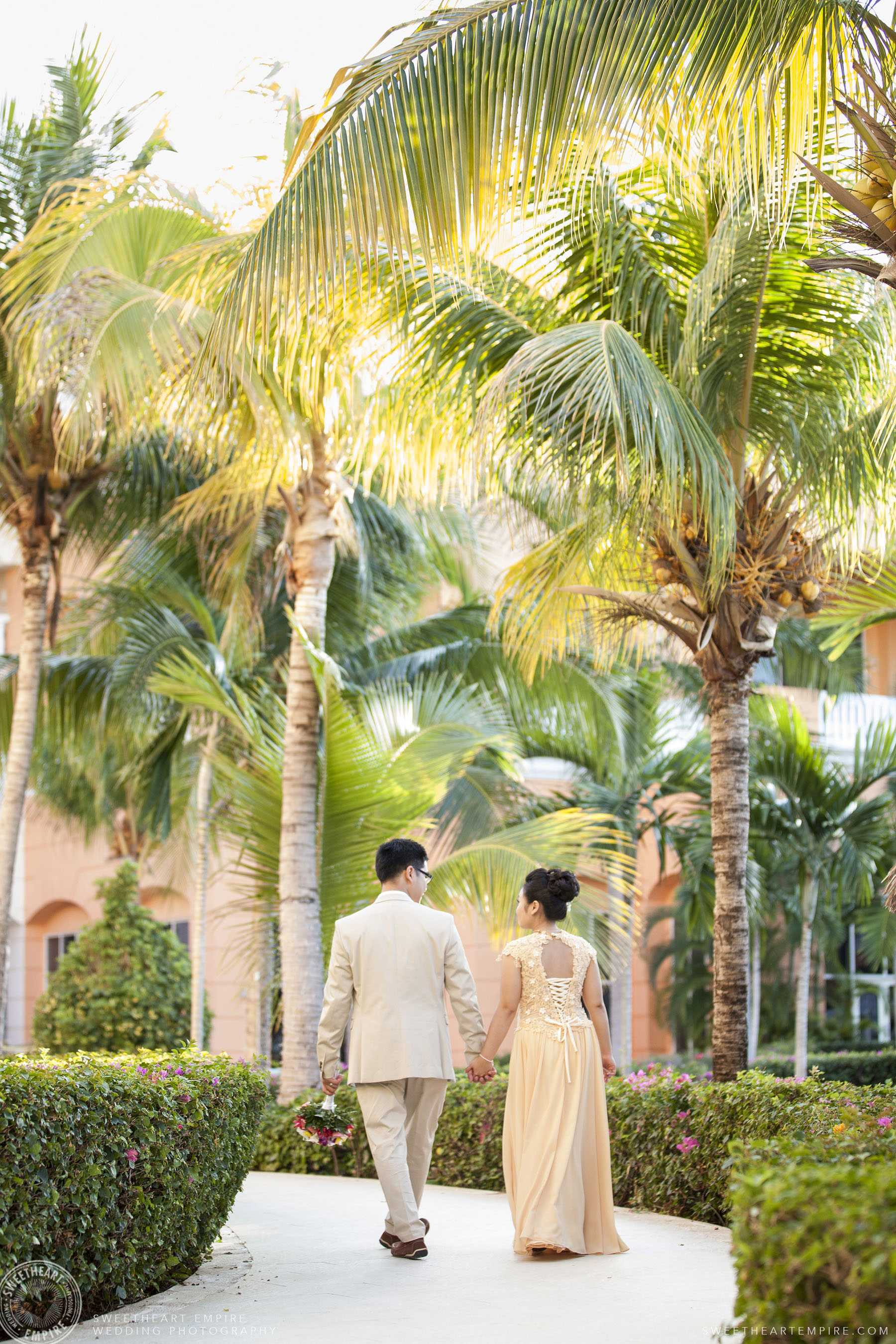 Bride and groom walking together; Iberostar Grand Hotel Rose Hall, in Montego Bay, Jamaica