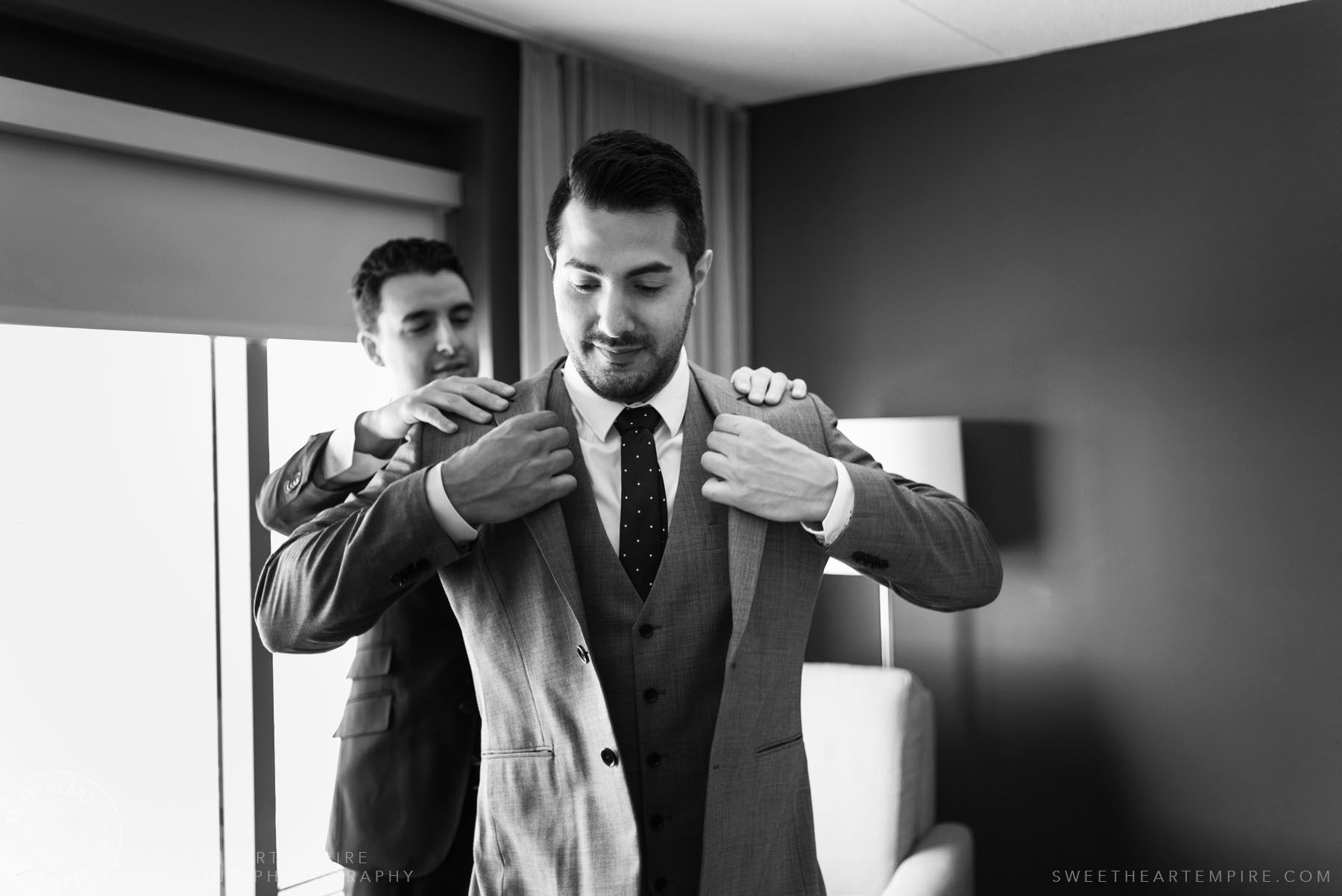 Best man helping groom get dressed; Eagles Nest Golf Club Wedding Photos