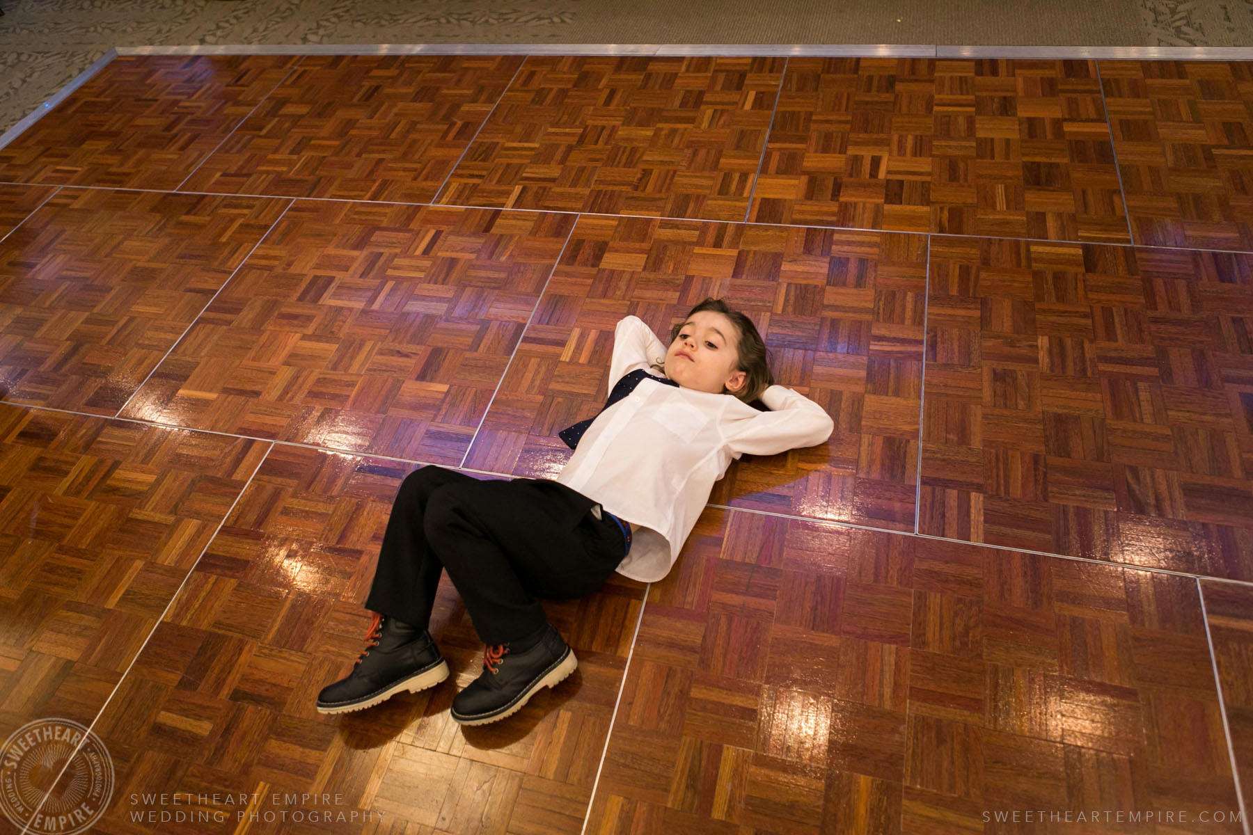 Little boy laying on dance floor, Eagles Nest Golf Club Wedding