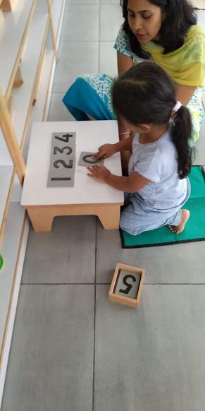 Child practicing the sandpaper numbers