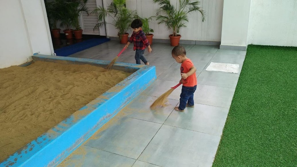 Toddlers independently cleaning up