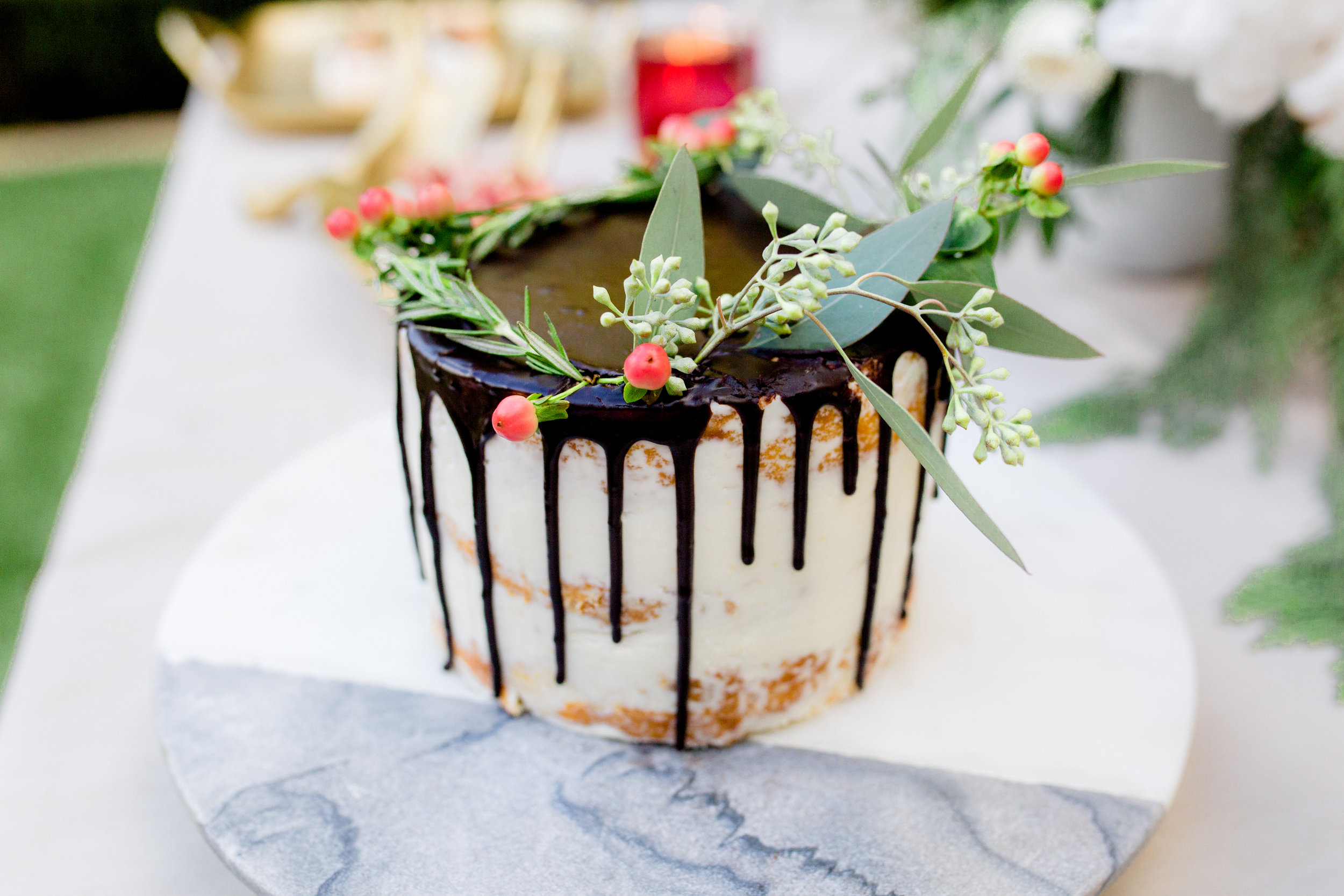Semi-naked chocolate drip cake decorated with fresh florals. Photo: Yasmin Roohi