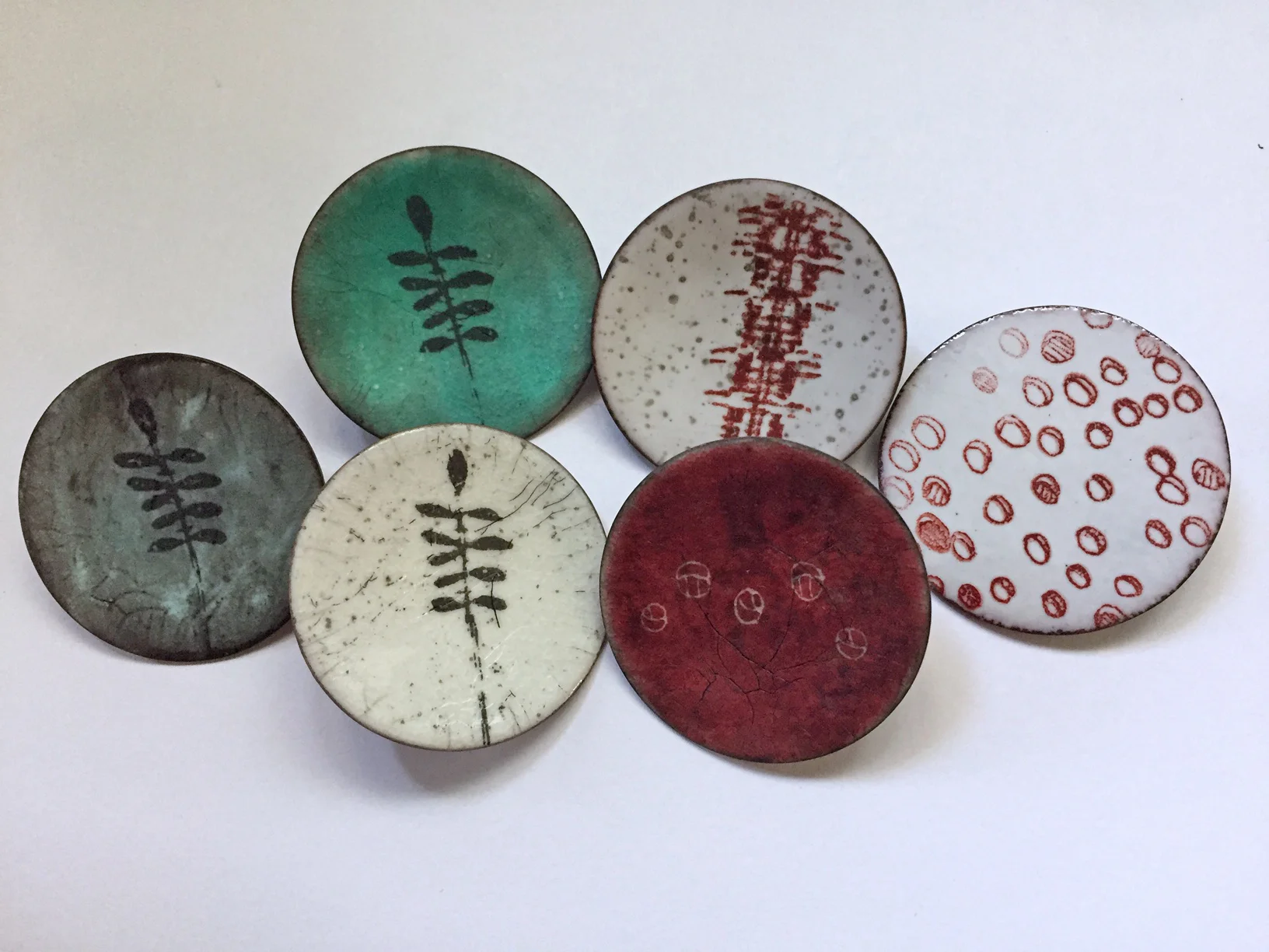Lapel pins with decals, silk screened images and sgraffitto designs.