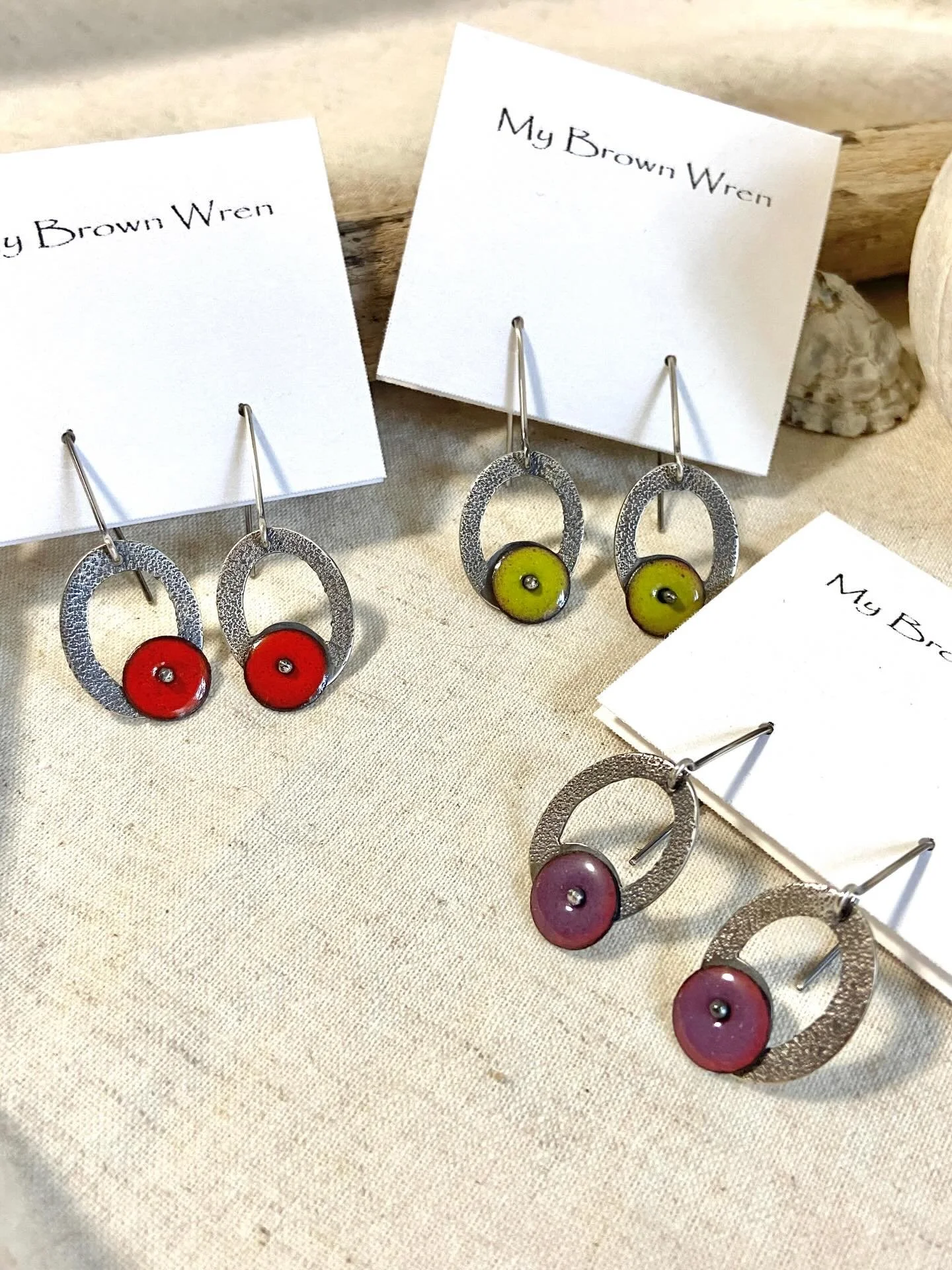 A new take on an old favorite ~ oval instead of round, dangles instead of posts, textured instead of smooth and smaller gemmy discs of enamel in bright, luminescent colors. Layering these gorgeous colors over a clear enamel base makes for colors that