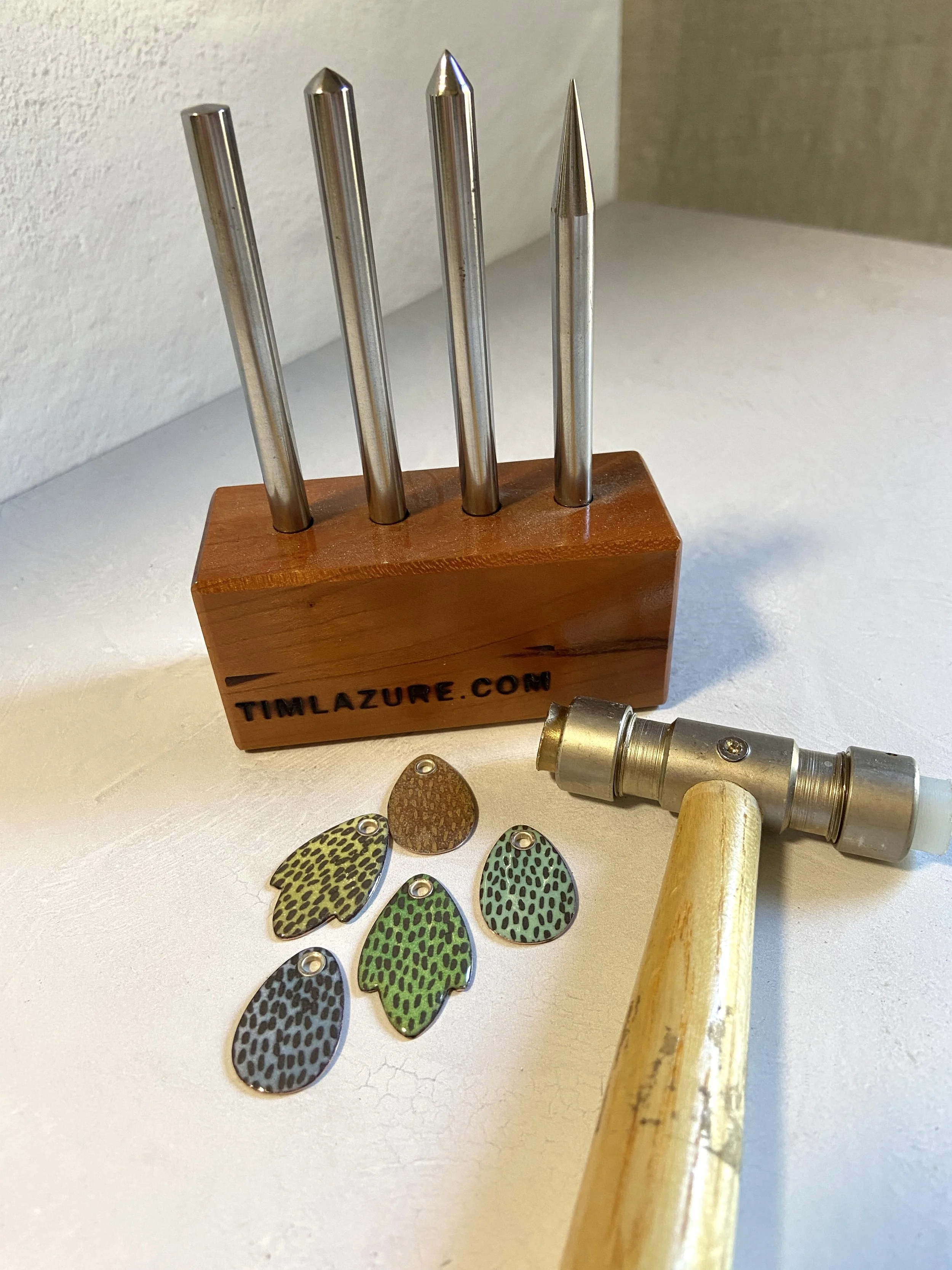 Enamel pendants with tube rivets, riveting tools and a riveting hammer