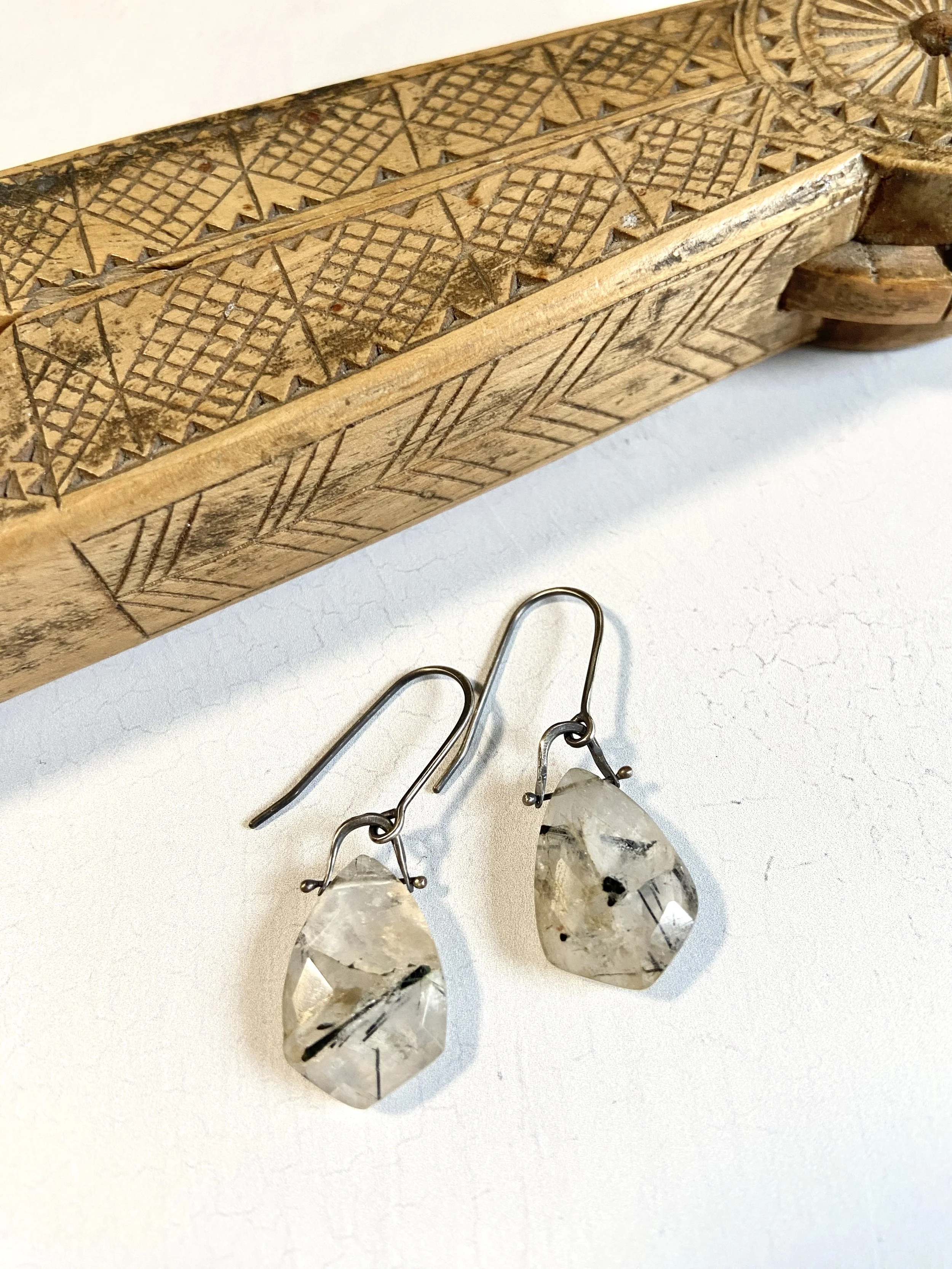 Dangle earrings featuring a quartz stone with tourmaline inclusions