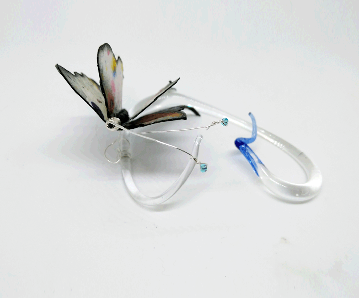 Whisked by A Cloud (view 2) Mixed media borosilicate, clear glass with blue tip, flame work tip and abstract painting on cotton watercolor paper with clear blue glass seed beads at tips of antenna... Wholesale Price: $95