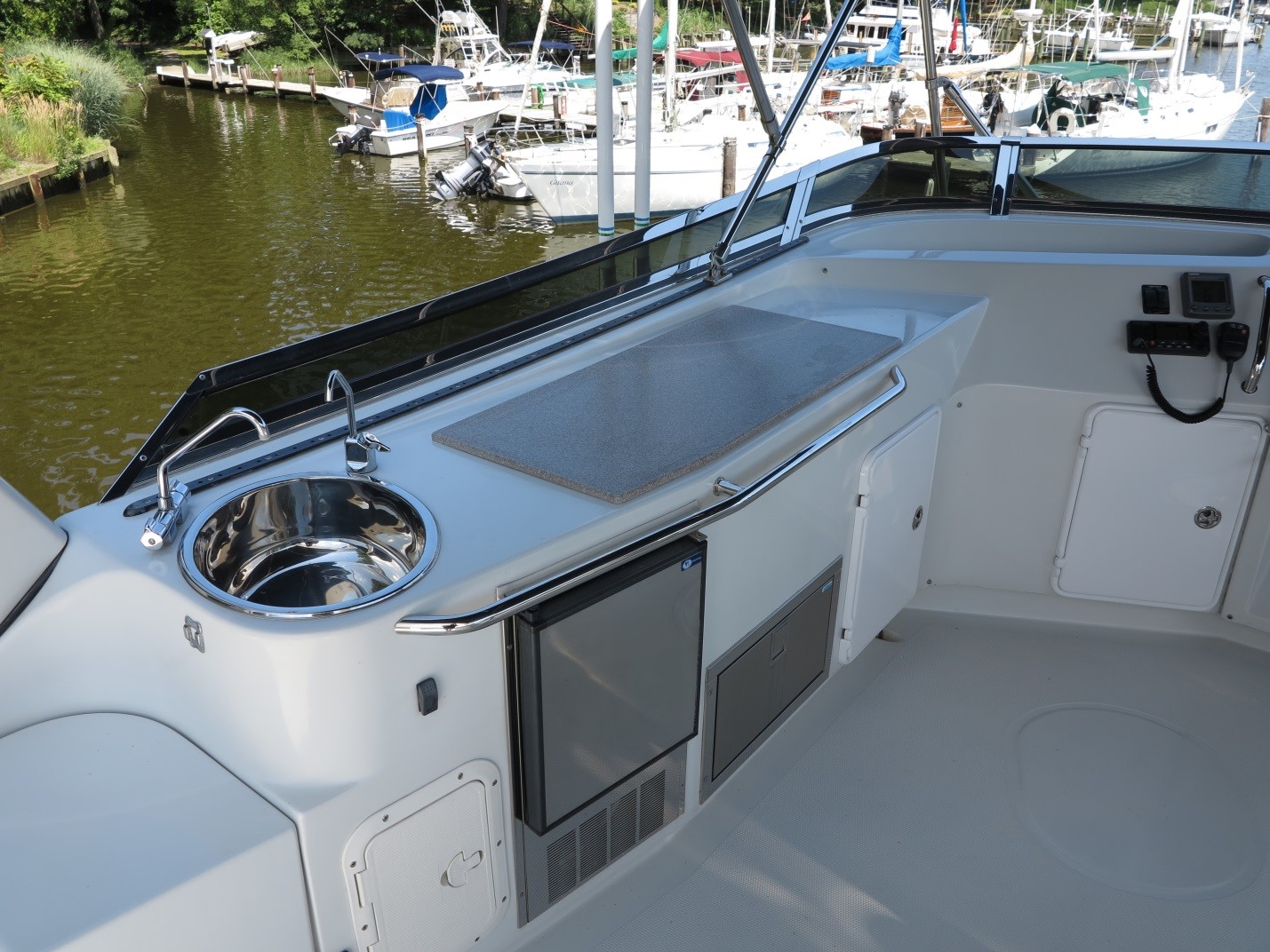 The updated flybridge area includes a Corian countertop, Seagull filtered water faucet, and access door to the inside of this large space. If the bridge was fully enclosed, this area could further configured for living on the flybridge. Without the grill, there is space above the fridge for a larger pull-out drawer to hold the many things we need for cruising, entertaining, and simply living aboard.