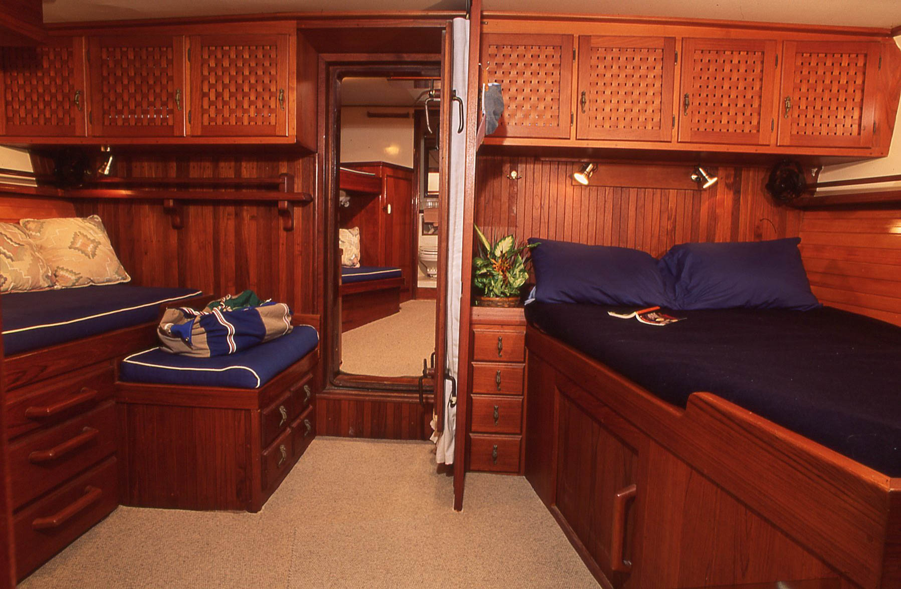 A master stateroom that works well offshore. Making the bed might be more tedious than an island berth arrangement, but it works. Note the separation between the berths in this cabin and the guest stateroom closer to the bow, with guest head beyond.