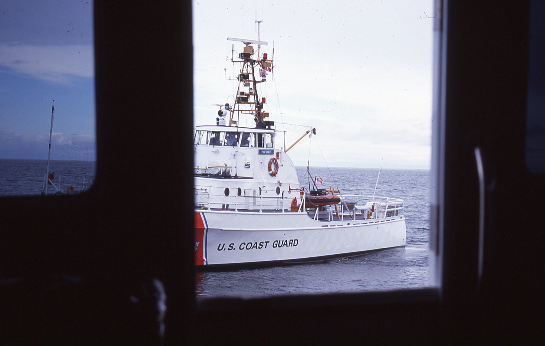 Prepare to be boarded! We are met by the Coast Guard off the coast of the U.S. Notice the difference between the partially open pilothouse doors and the tinted window. I much prefer seeing the real world outside, where colors are crisper, and a sunny day on the water feels good.