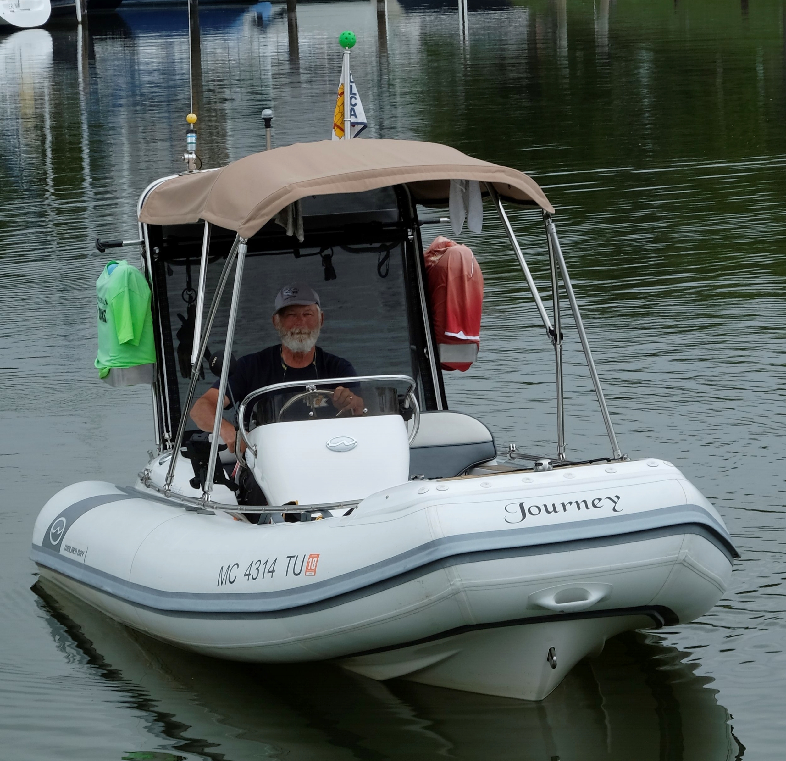 Take a standard Walker Bay Generation 450 and turn it into a competent cruising boat for a solo cruiser. Note the stainless structure added for the enclosure, hanging fenders, and useful grab rail. Nice little cruising boat that will be at home in Michigan when this trip is done.