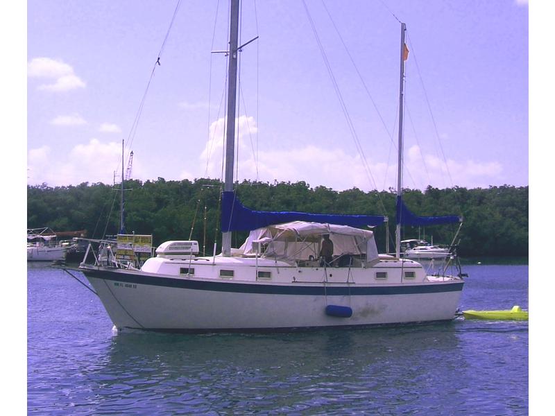 Vintage Gulfstar center cockpit sailboat is getting close to being a trawler. Wonder how often those sail covers come off...