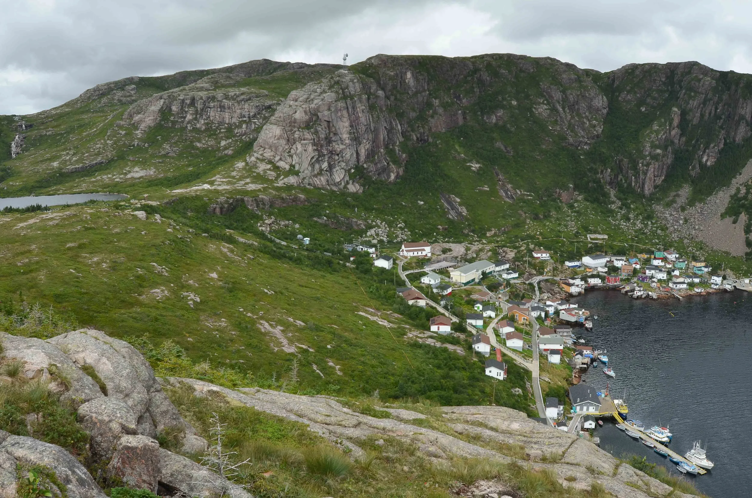 The out village town of Francois, pronounced Franz Way by the locals. Mary and I hiked to the viewpoint you see in the photo. On the way up we saw a black bear running away in the distance behind the town water supply. The next day I rebuilt an outboard carburetor for a local fisherman. They only had a few rusty tools and no cleaner. After I cleaned and reassembled the carb and gave them some fresh gas, the outboard started in a cloud of blue smoke and ran just fine. The morning we left there was a cup of fresh berries in the cockpit.