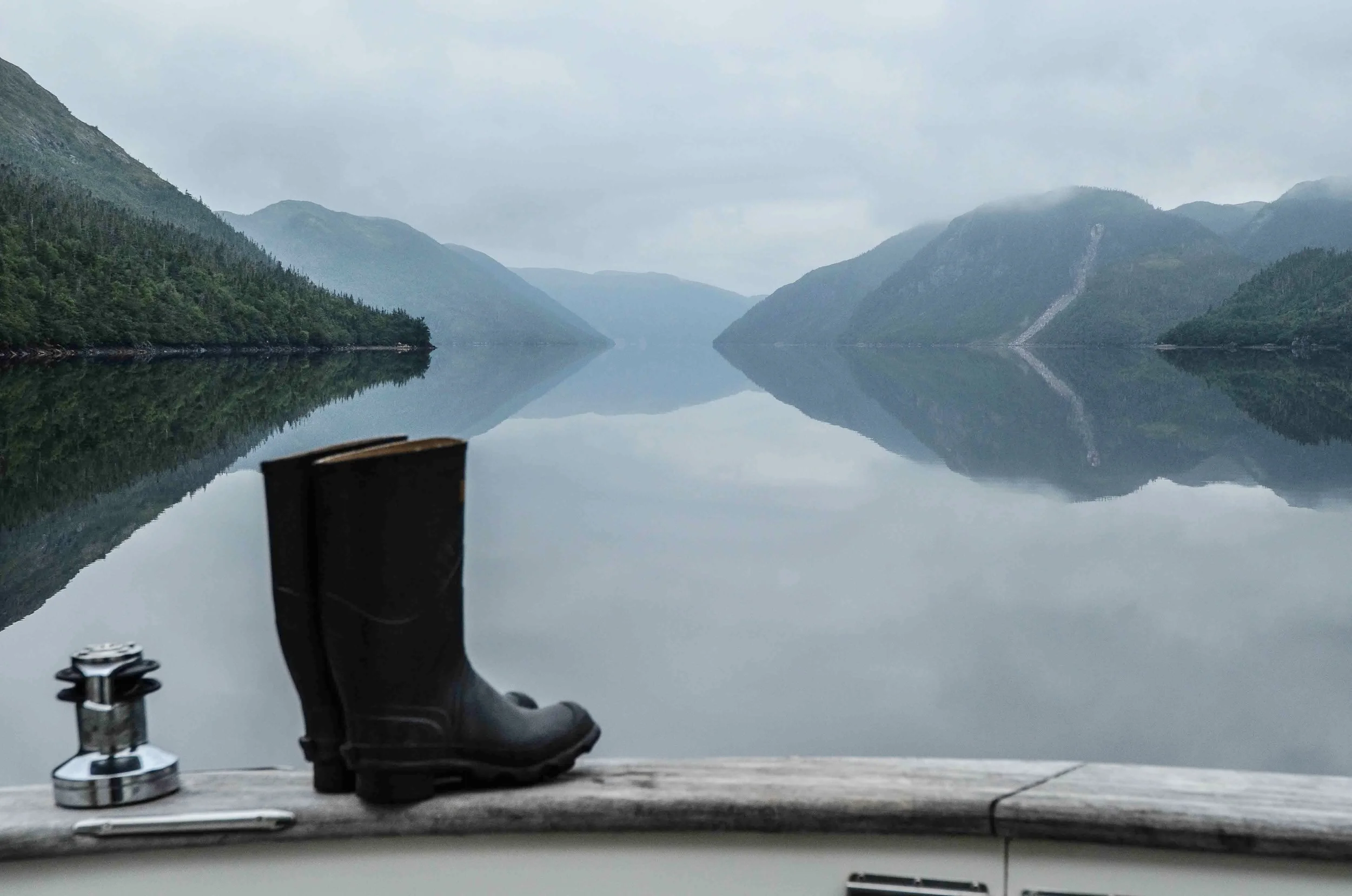Typical early morning scene in Newfoundland’s fjords. It is usually overcast in the mornings with light or sometime heavy fog. By mid-morning the fog lifts exposing the mountains. Mary’s boots were waiting for her. We wore wellies like these for all inland exploring inside the fjords. In addition to exploring ashore we also did quite a bit of shoreline dinghy exploring. We even caught two near-shore lobster for dinner from the dink with a dip net.