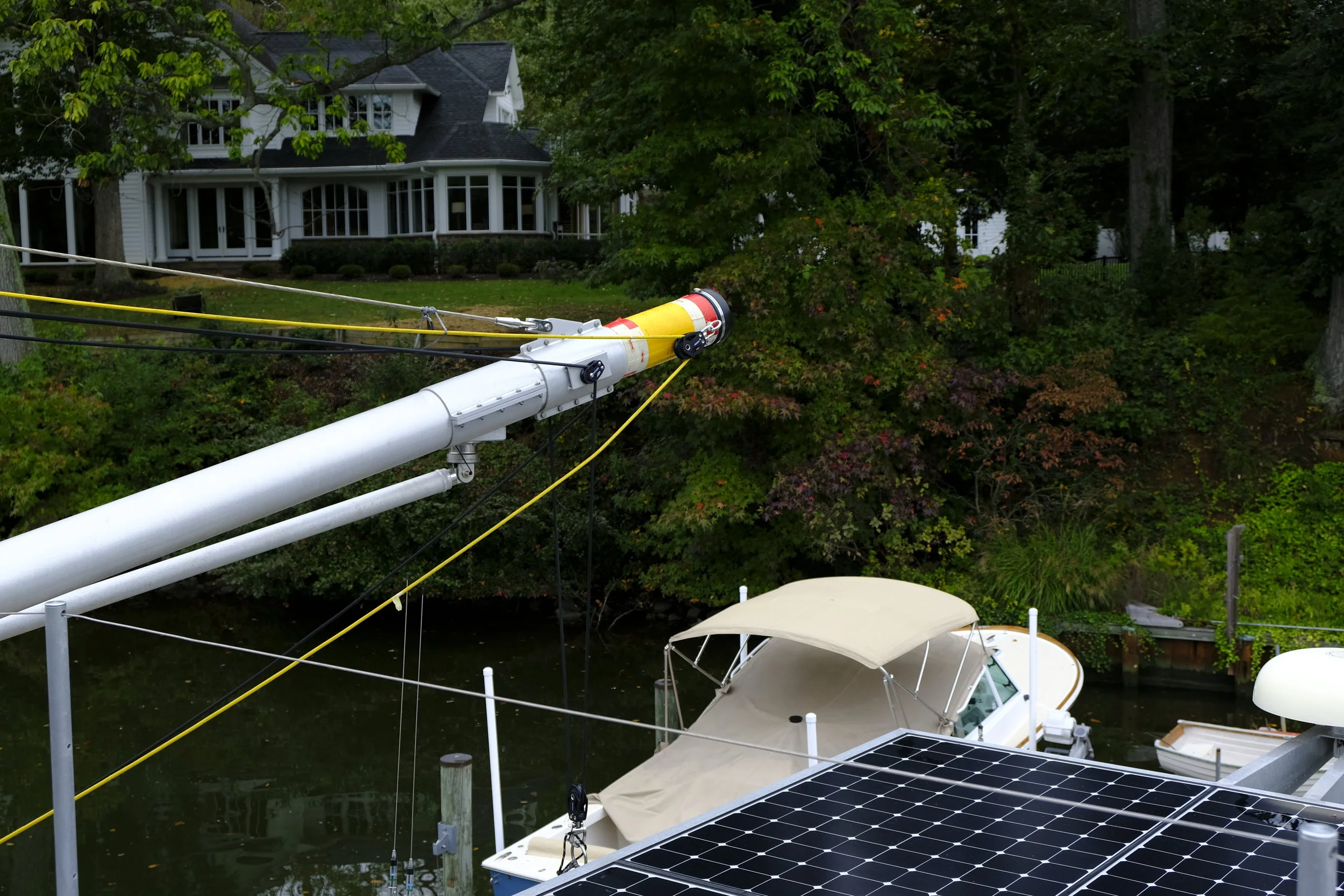 Details of the booms show the lines used to lift the dinghy and control the boom. All lines are super-strong Spectra lines, way stronger than their diameter might suggest. Note the solar array over the aft deck.