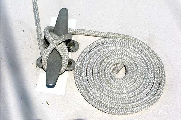 The excess coil of dock line will stay much cleaner and splinter-free onboard your boat than laying on sometimes nasty transient docks. But rather than the Flemish Flake as seen here, it is best that the excess line be coiled and neatly hung from a side rail or lifeline off the deck.