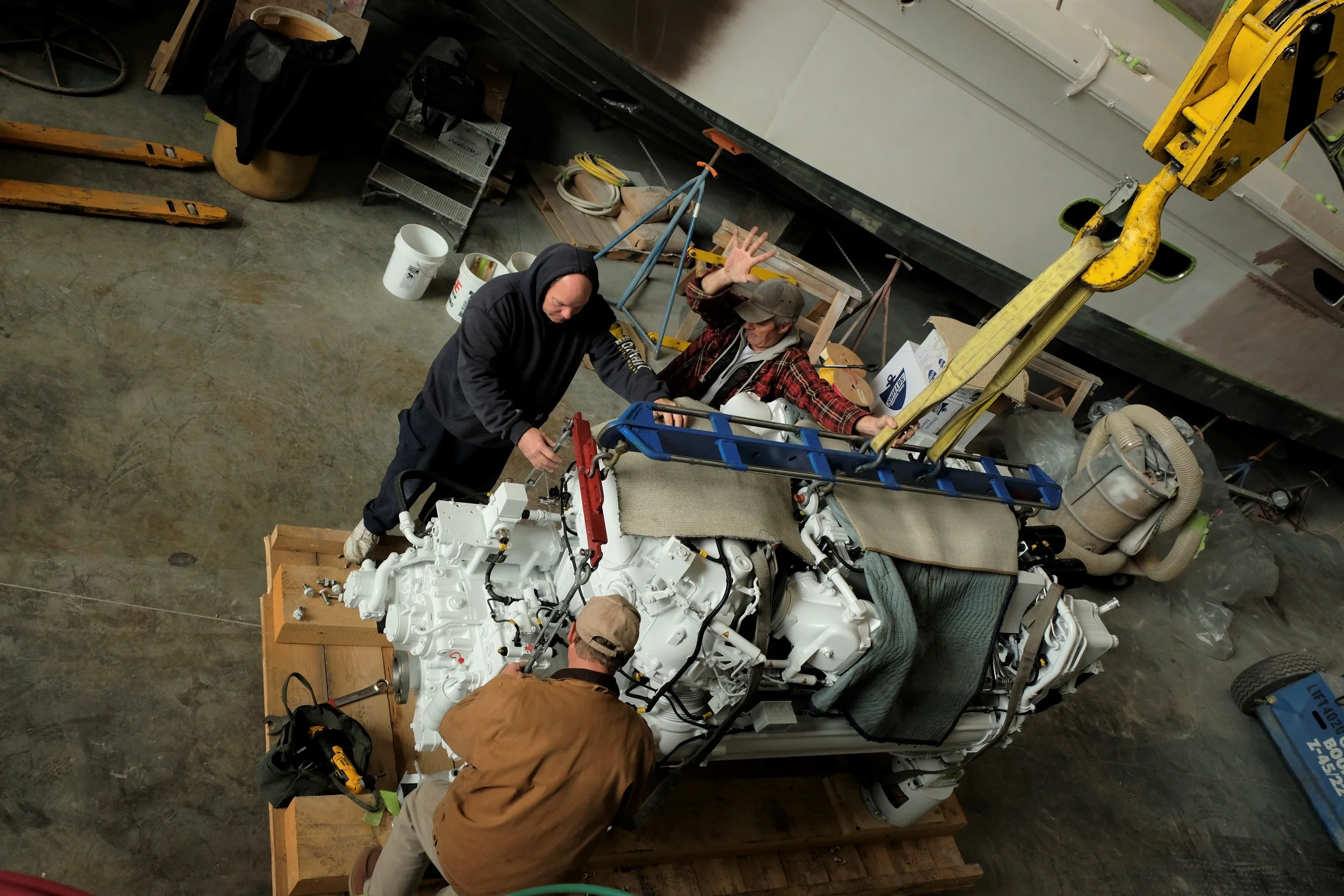 Note the special MTU lifting bracket engineered to safely to move these engines around. Pieces of carpet and extra straps are added for extra insurance so no damage will occur during the installation process.