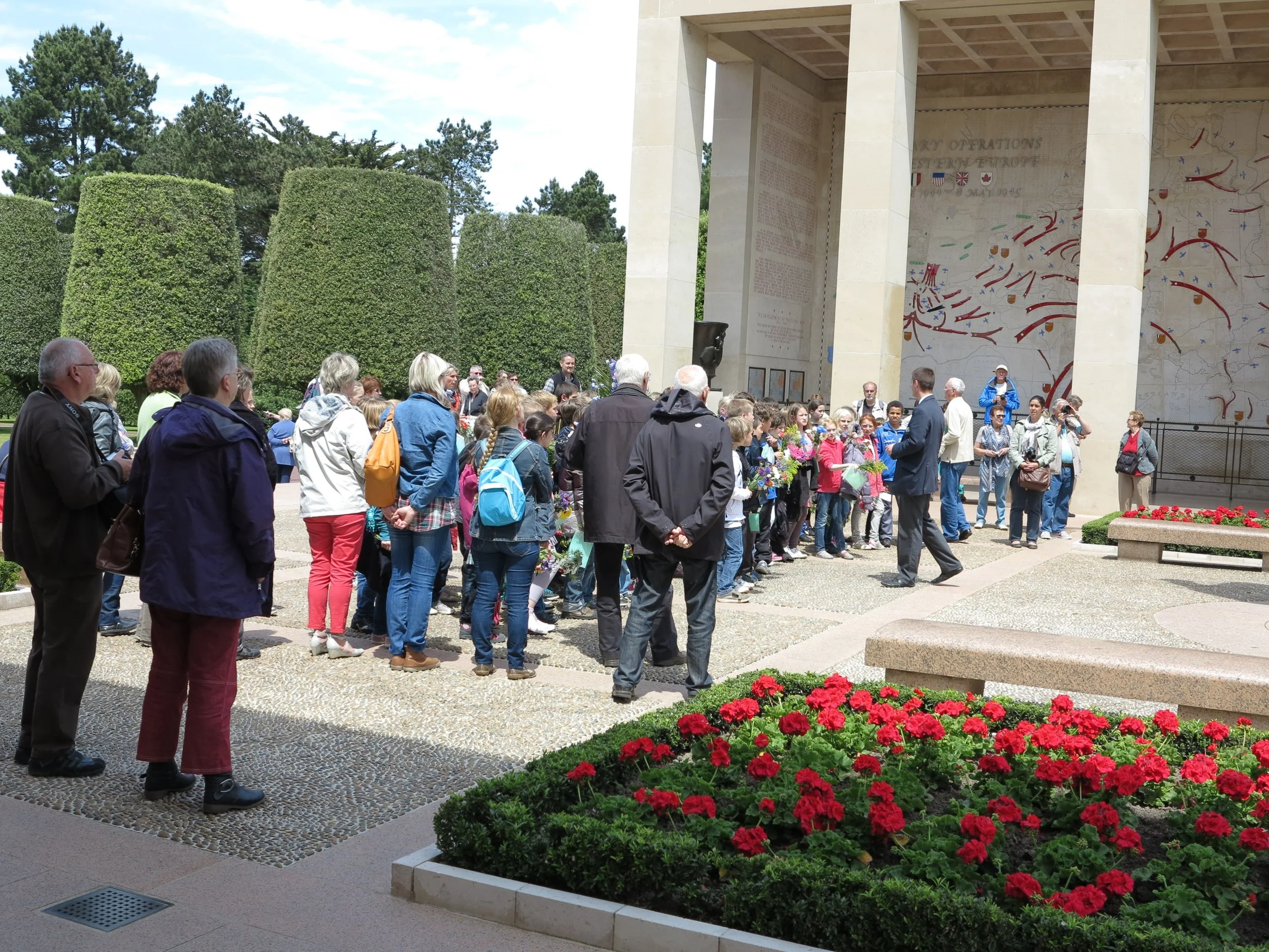 At the Normandy American Cemetery & Memorial, in Colleville-sur-Mer, France. Bus loads of French school children arrive at the memorial, with flowers and a paper with a specific grave location, to honor a soldier killed in the invasion of 1944. This brings this history up close and personal for these children, in an area of France that remains grateful for the sacrifice made by so many to free France from Nazi Germany.