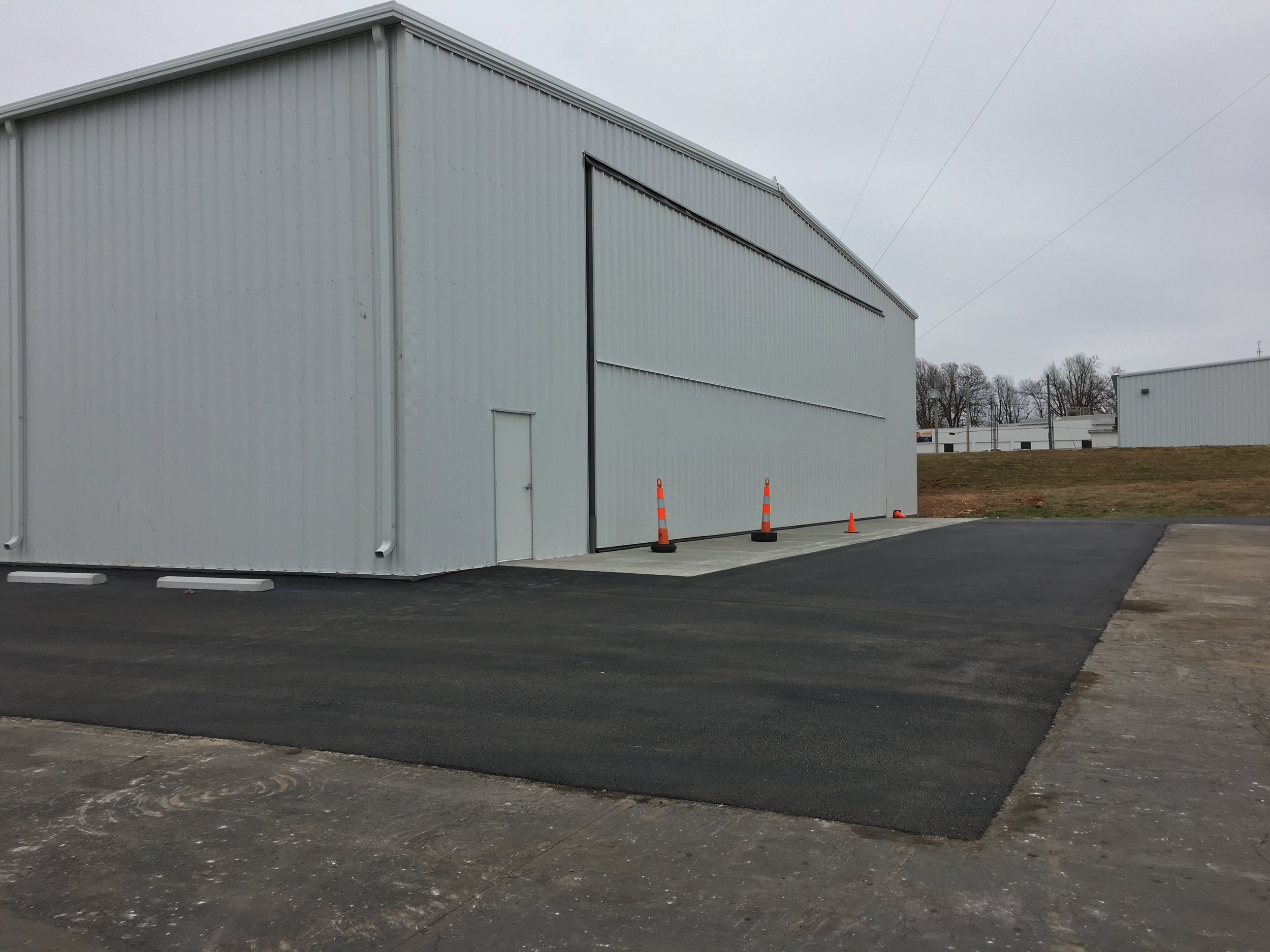 Recently completed asphalt paving project by Springfield Striping &amp; Sealing, with safety cones marking the area near Springfield, MO.