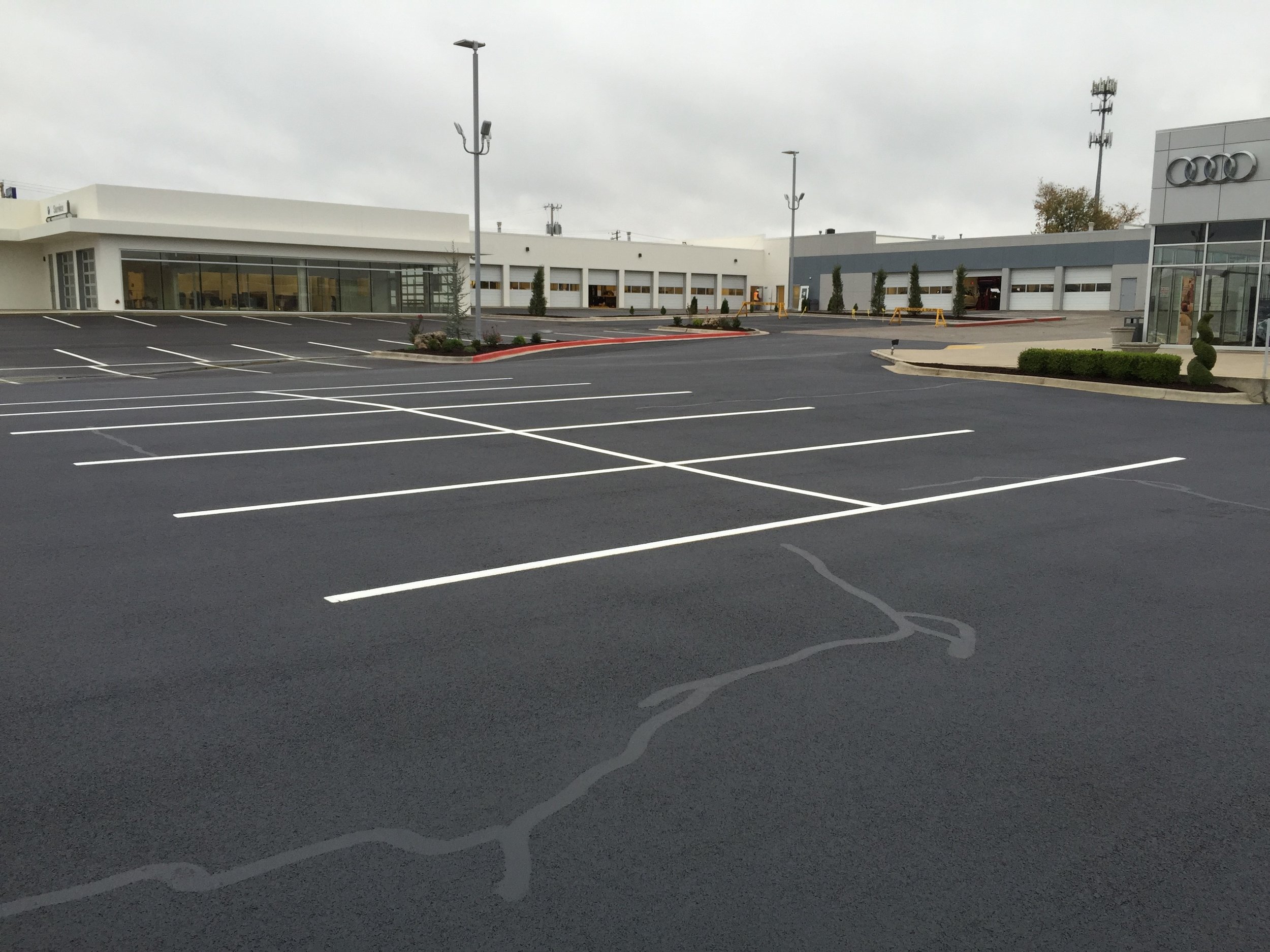 View of a car dealership's freshly crack filled &amp; seal coated parking lot coated by Springfield Striping and Sealing. 