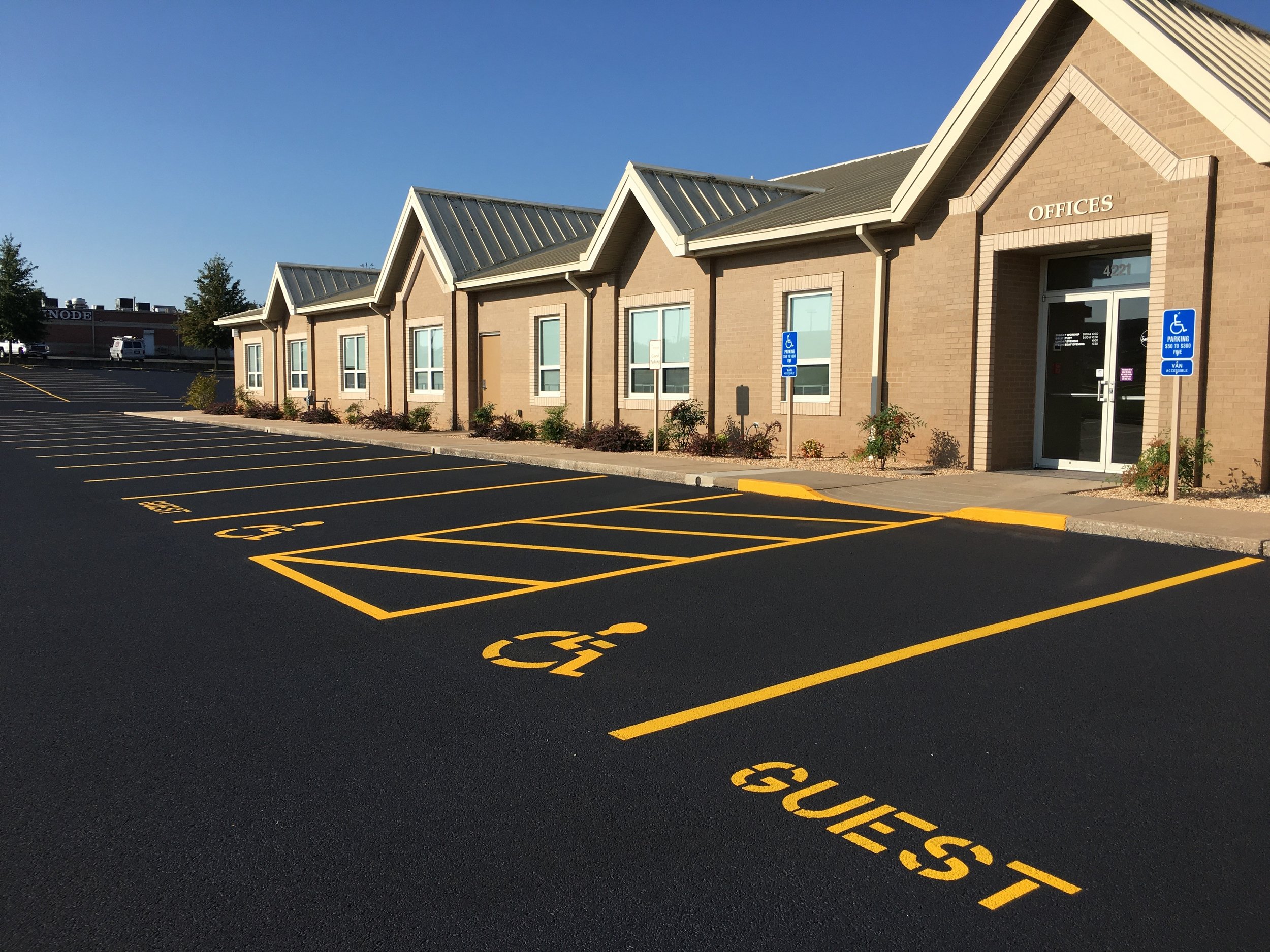 Fresh asphalt sealcoating on a large commercial parking lot, enhancing the durability and appearance of the surface, a project by Springfield Striping and Sealing near Springfield, Missouri.