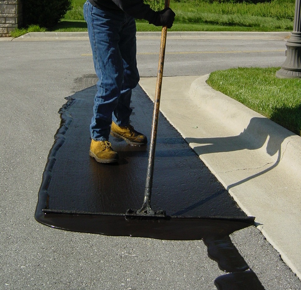 A close up picture of a Springfield Striping and Sealing employee working hard paving a road near Springfield Missouri. 