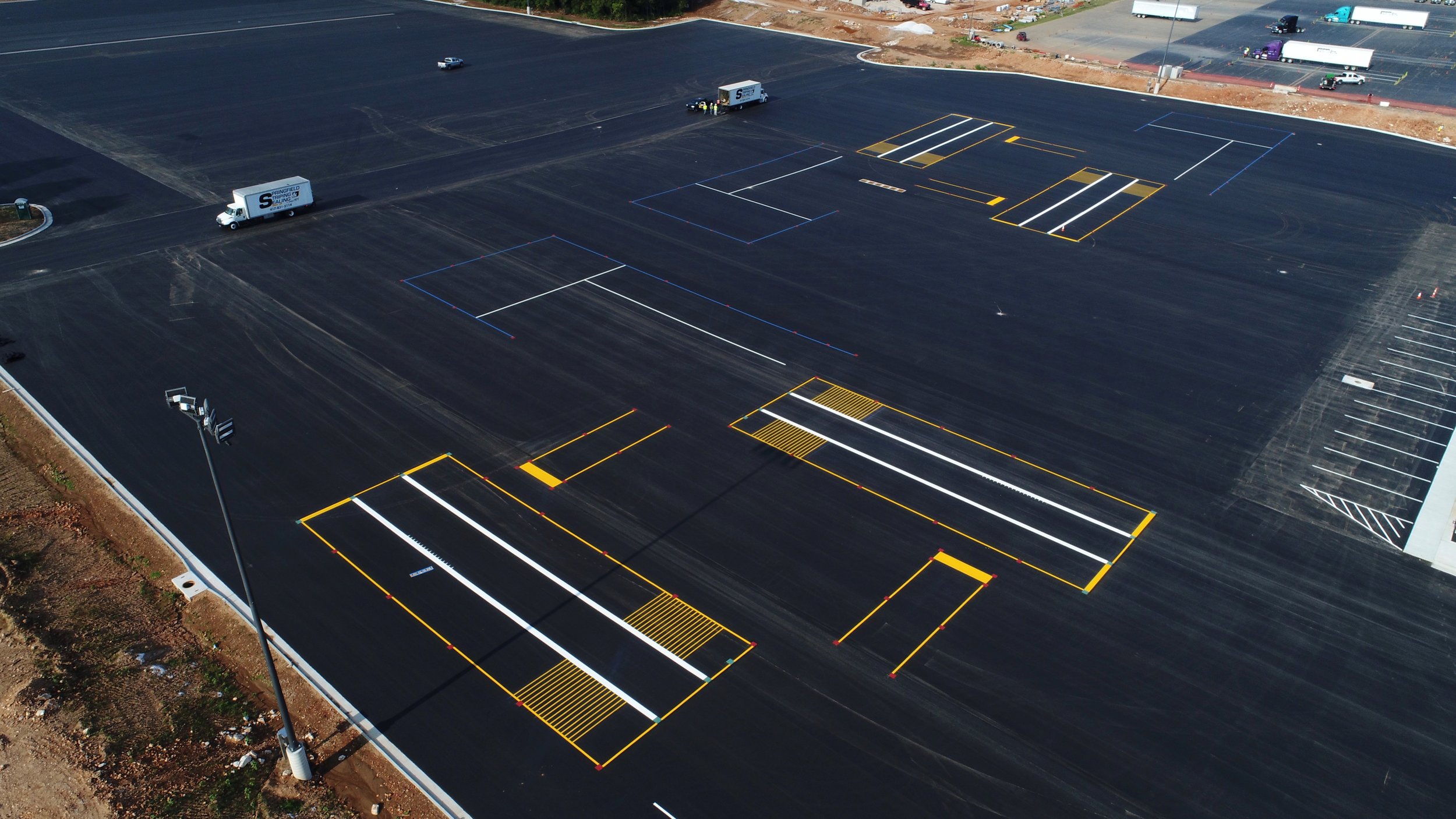 Wide-angle view of a large, freshly striped parking area, demonstrating the effective traffic management and parking layout by Springfield Striping and Sealing in Springfield, Missouri.