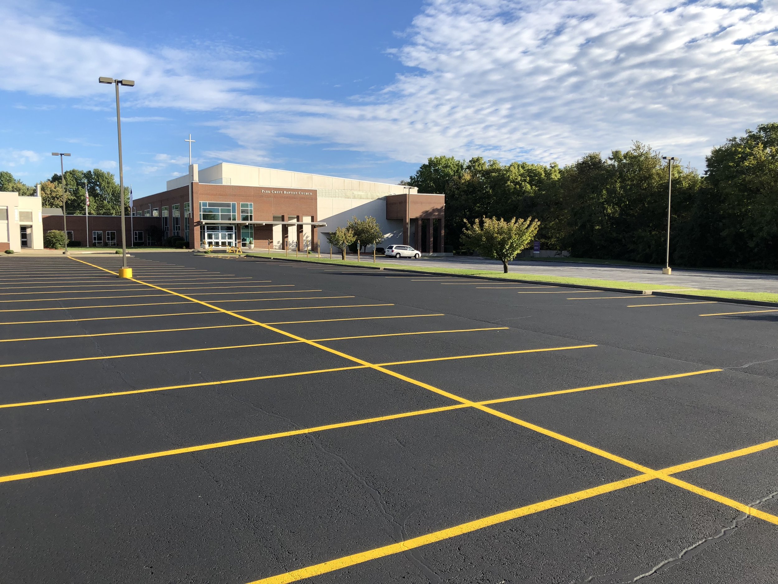 A church parking lot near Springfield, Missouri, displays meticulous asphalt paving and bright yellow striping, reflecting the quality work of Springfield Striping and Sealing. 