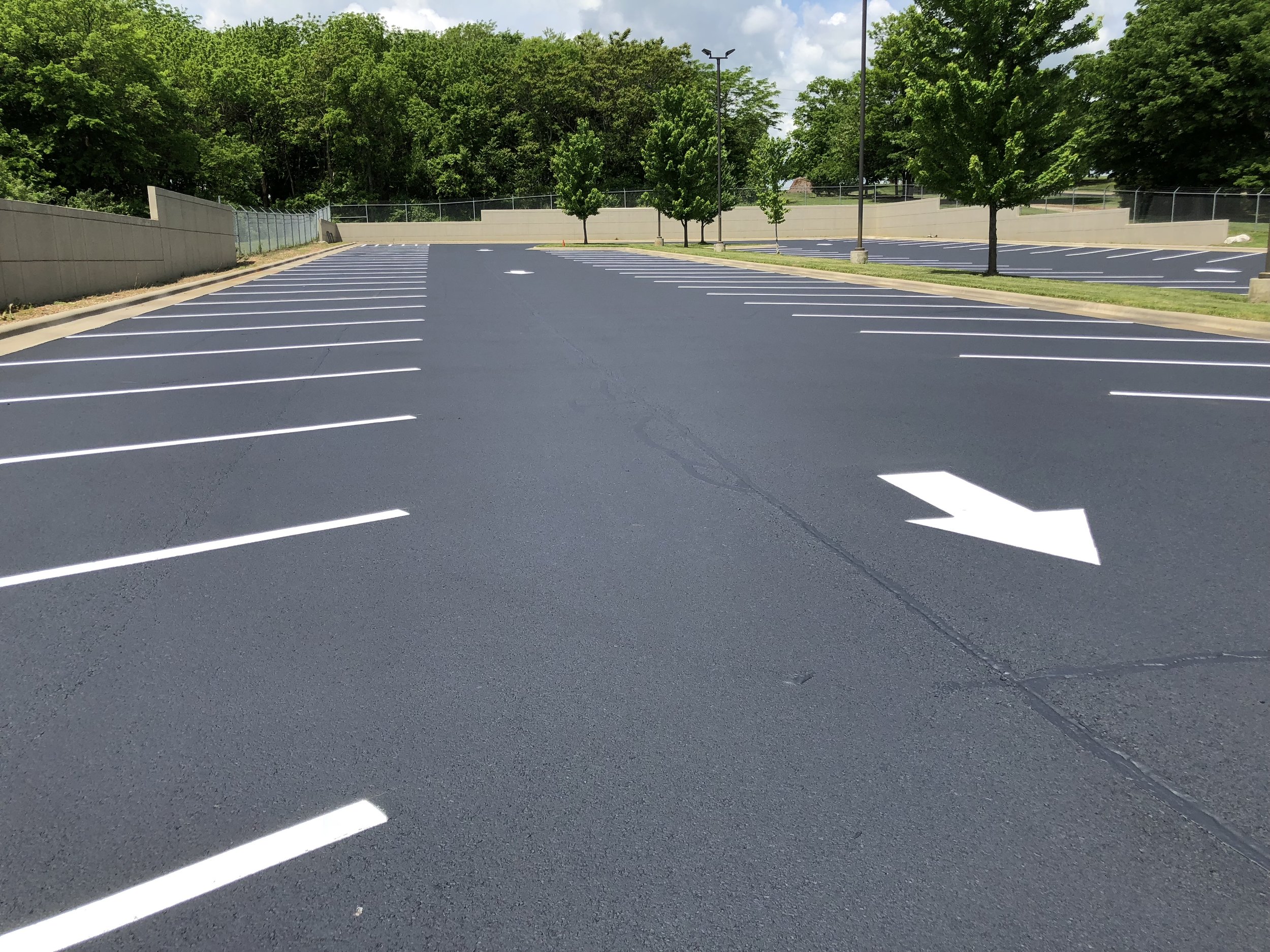 A well-maintained asphalt paved parking lot with crisp white striping done by Springfield Striping and Sealing. 