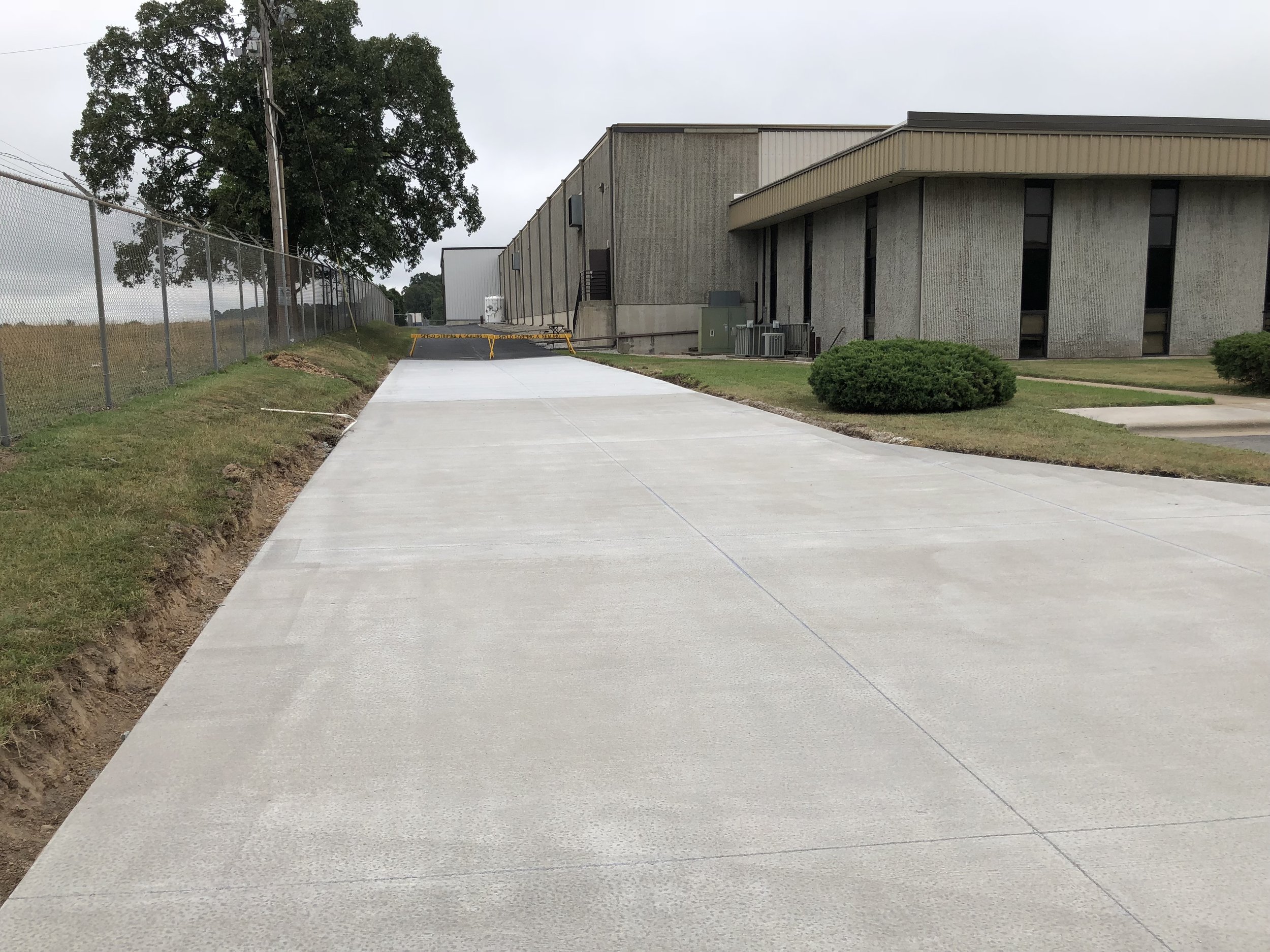 Freshly sealed and striped parking lot near Springfield, Missouri, blocked off to protect where Springfield Striping and Sealing replaced old asphalt to withstand heavy traffic loads.