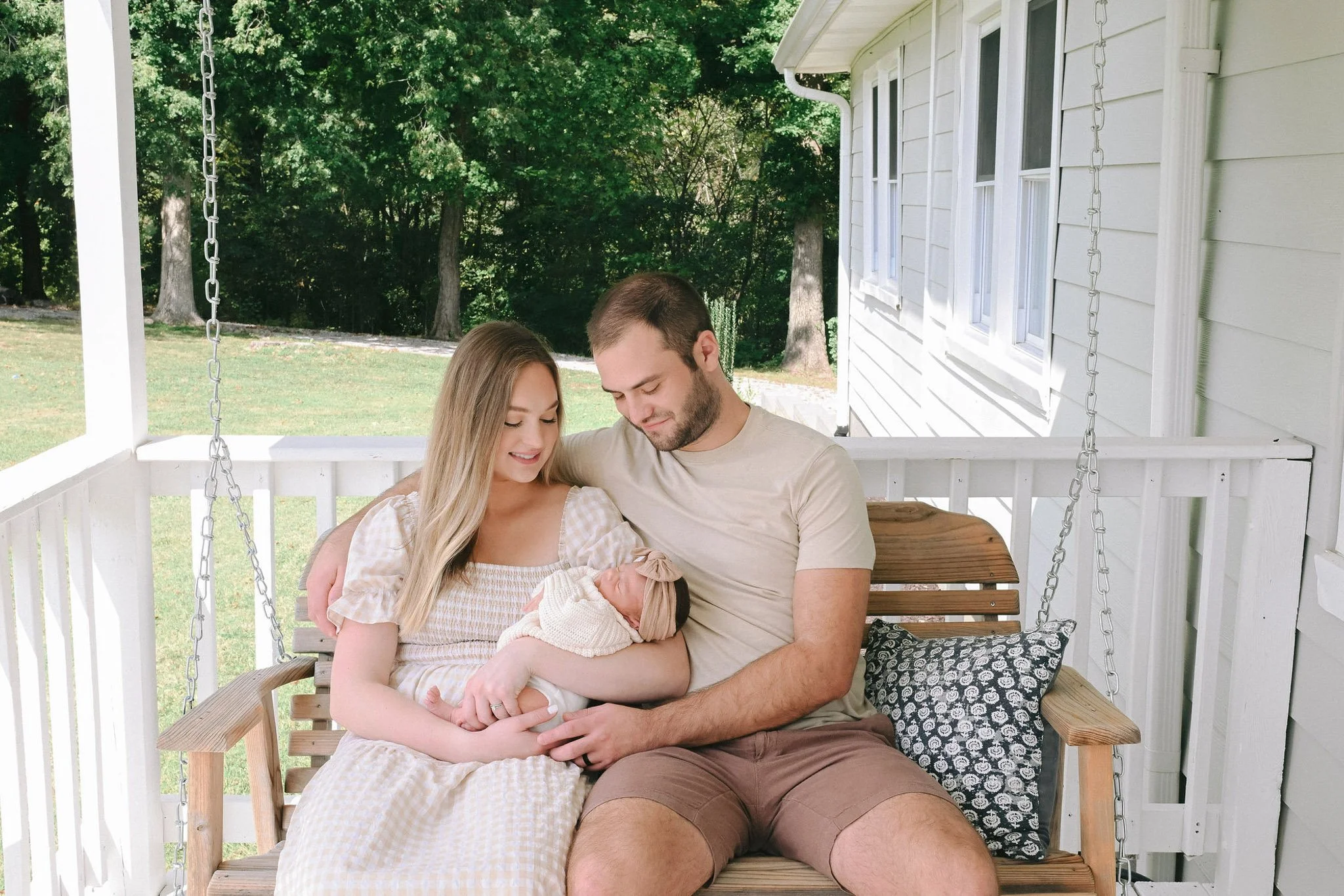 couple on porch swing with new baby
